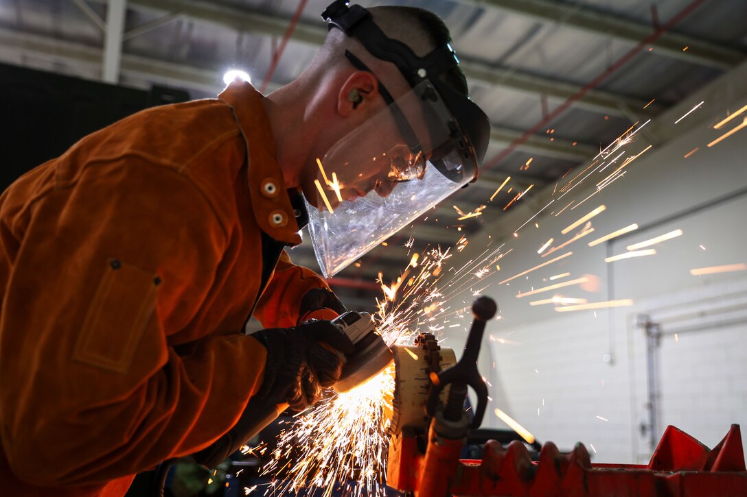 U.S. Army Staff Sgt. Allen Kemper, ARCENT Innovation and Manufacturing Center (AIM-C) NCOIC, uses an angle grinder to smooth out a metal pipe at the AIM-C in the U.S. Central Command area of responsibility.