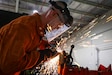 U.S. Army Staff Sgt. Allen Kemper, ARCENT Innovation and Manufacturing Center (AIM-C) NCOIC, uses an angle grinder to smooth out a metal pipe at the AIM-C in the U.S. Central Command area of responsibility. (U.S. Army photo by Sgt. Brandon Hernandez)