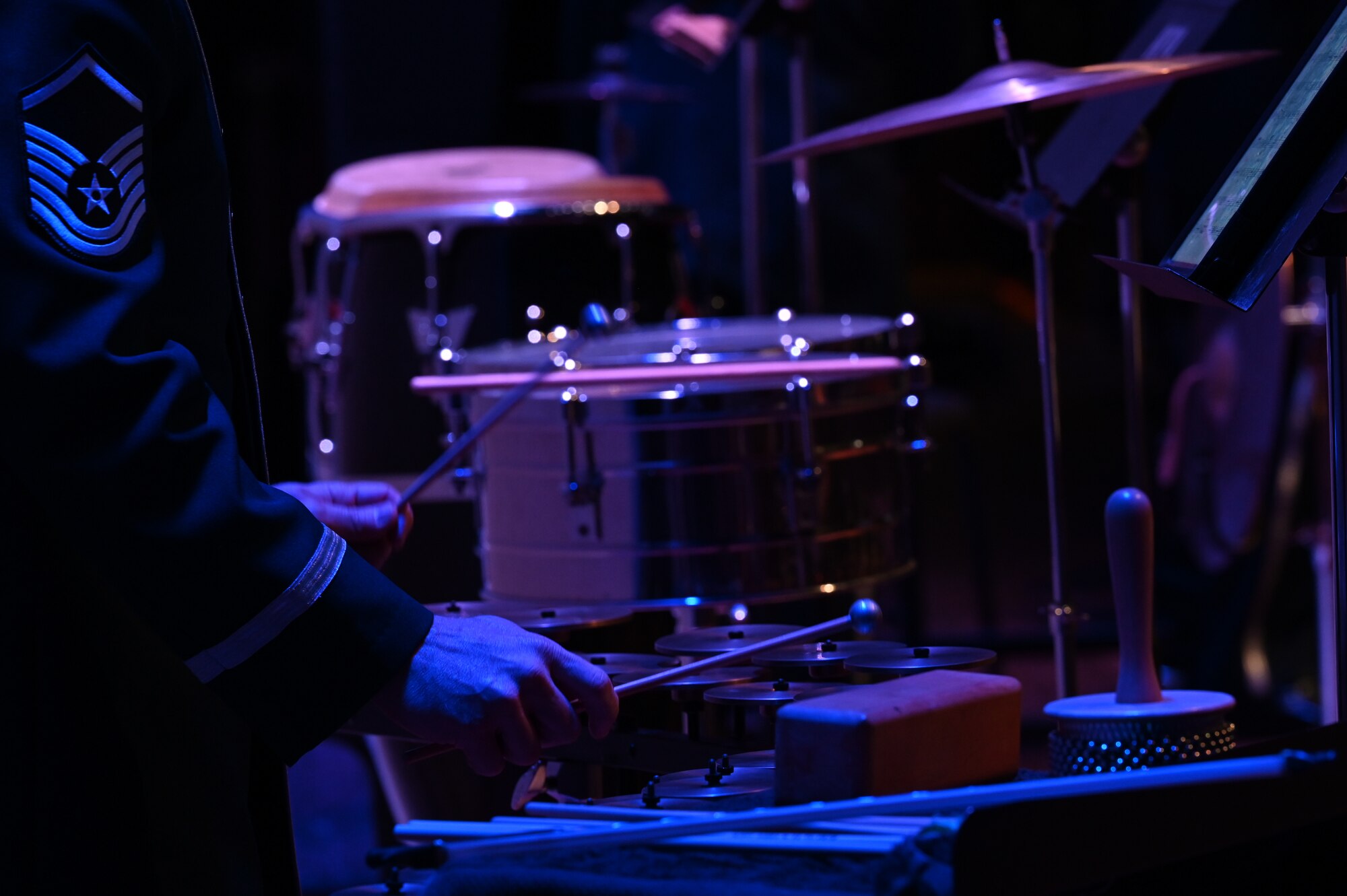 Airmen from the Air Force Concert band plays an instrument with two mallets.