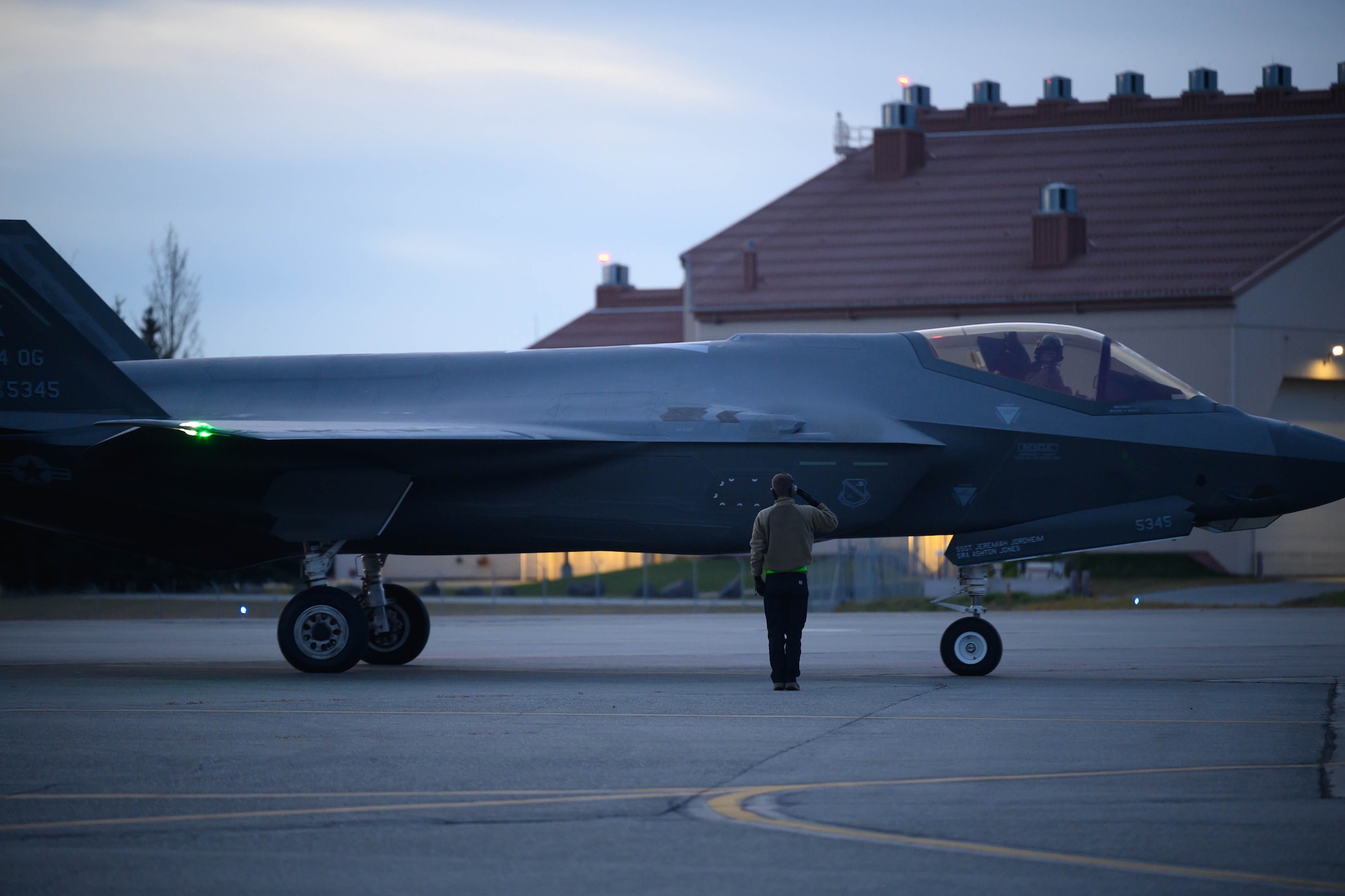 An Airman salutes an aircraft.