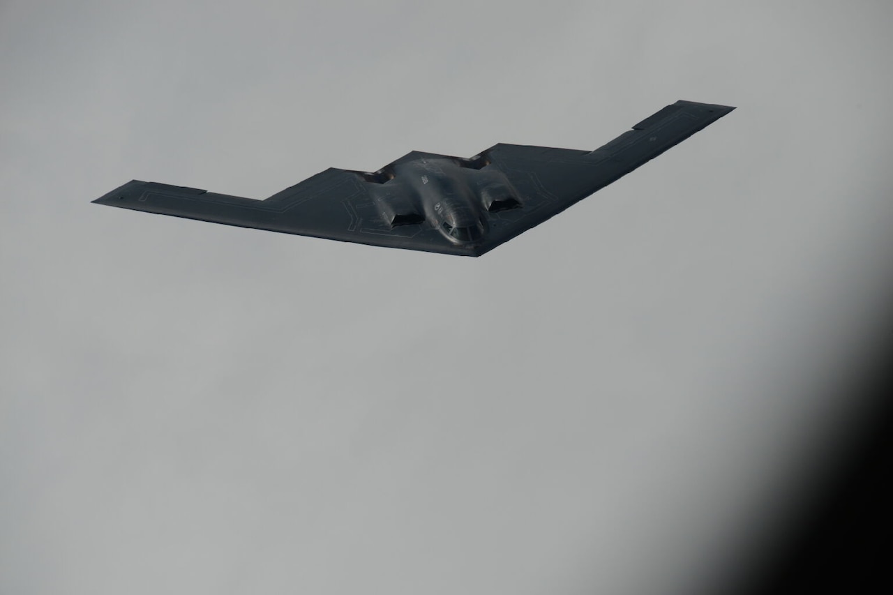 A wing-shaped aircraft flies against a grey sky.