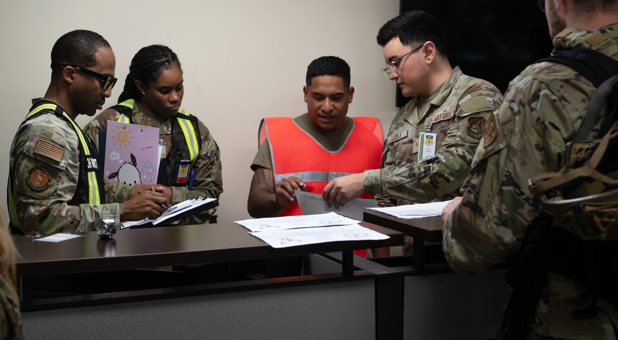 36th Wing Inspection Team members review a 36th Force Support Squadron personnel specialist's process during a Personnel Deployment Function Line for Exercise Slingstone 24-4 at Andersen Air Force Base, Guam, October 18, 2024. A PDF Line is a comprehensive process involving multiple support agencies taking care of Airmen who are about to deploy. During Slingstone 24-4, Andersen tested this process and logged what is done efficiently and what could be improved should a real-world scenario happen. (U.S. Air Force Photo by Staff Sgt. Pedro Tenorio)
