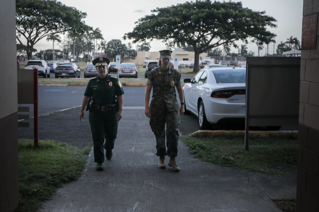 U.S. Marine Corps Maj. Kellie Lundmark, the Provost Marshall for Marine Corps Base Hawaii, and Maj. Shellie Paiva, commander, Honolulu Police Department, District 4, discuss an interview with KHON 2 about joint traffic enforcement on the H-3 Highway near MCBH, Oct. 16, 2024. This collaboration between HPD and the MCBH Provost Marshal’s Office was in response to community concerns about safety on the H-3, marking the first joint traffic enforcement exercise between these two agencies, with hopes to collaborate more in the future. (U.S. Marine Corps photo by Lance Cpl. Samuel Estridge)
