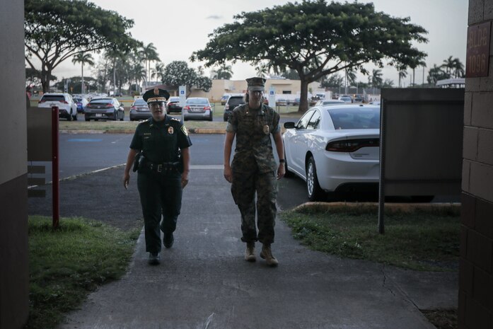 U.S. Marine Corps Maj. Kellie Lundmark, the Provost Marshall for Marine Corps Base Hawaii, and Maj. Shellie Paiva, commander, Honolulu Police Department, District 4, discuss an interview with KHON 2 about joint traffic enforcement on the H-3 Highway near MCBH, Oct. 16, 2024. This collaboration between HPD and the MCBH Provost Marshal’s Office was in response to community concerns about safety on the H-3, marking the first joint traffic enforcement exercise between these two agencies, with hopes to collaborate more in the future. (U.S. Marine Corps photo by Lance Cpl. Samuel Estridge)