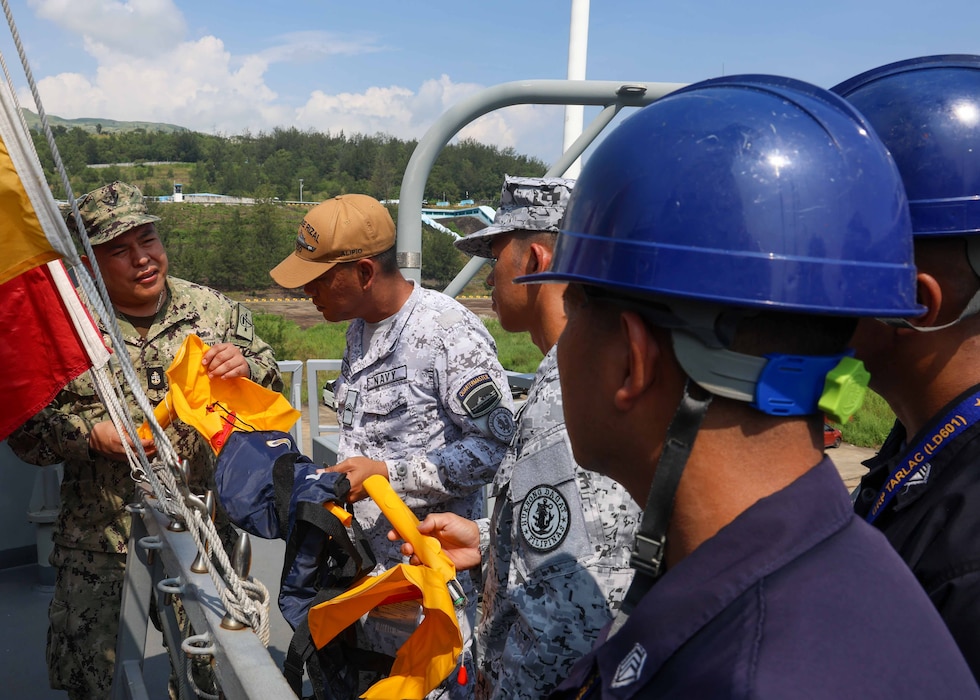 241009-N-DM318-1002 SUBIC, Philippines (October 9, 2024) U.S. Navy Chief Boatswain's Mate Francisco Fuentes, from East Rutherford, New Jersey, attached to Commander, Destroyer Squadron (DESRON) 7 instructs Philippine Navy Sailors on lifejacket inspection during a hands-on refueling-at-sea training aboard the Philippine Navy frigate BRP Jose Rizal (FF 150) as part of Sama Sama 2024, Oct. 9, 2024. Sama Sama is a bilateral exercise hosted by the Philippines and United States, with participants from Australia, Canada, France, and Japan, designed to promote regional security cooperation, maintain and strengthen maritime partnerships, and enhance maritime interoperability. (U.S. Navy photo by Mass Communication Specialist 2nd Class Ange Olivier Clement)