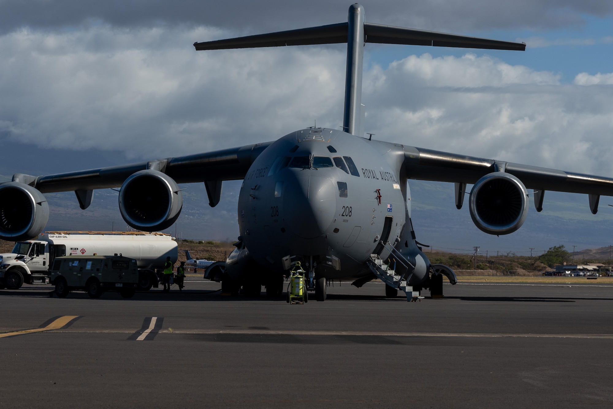 A C-17 Globemaster III aircraft has routine maintenance performed on it by U.S. and Australian forces.