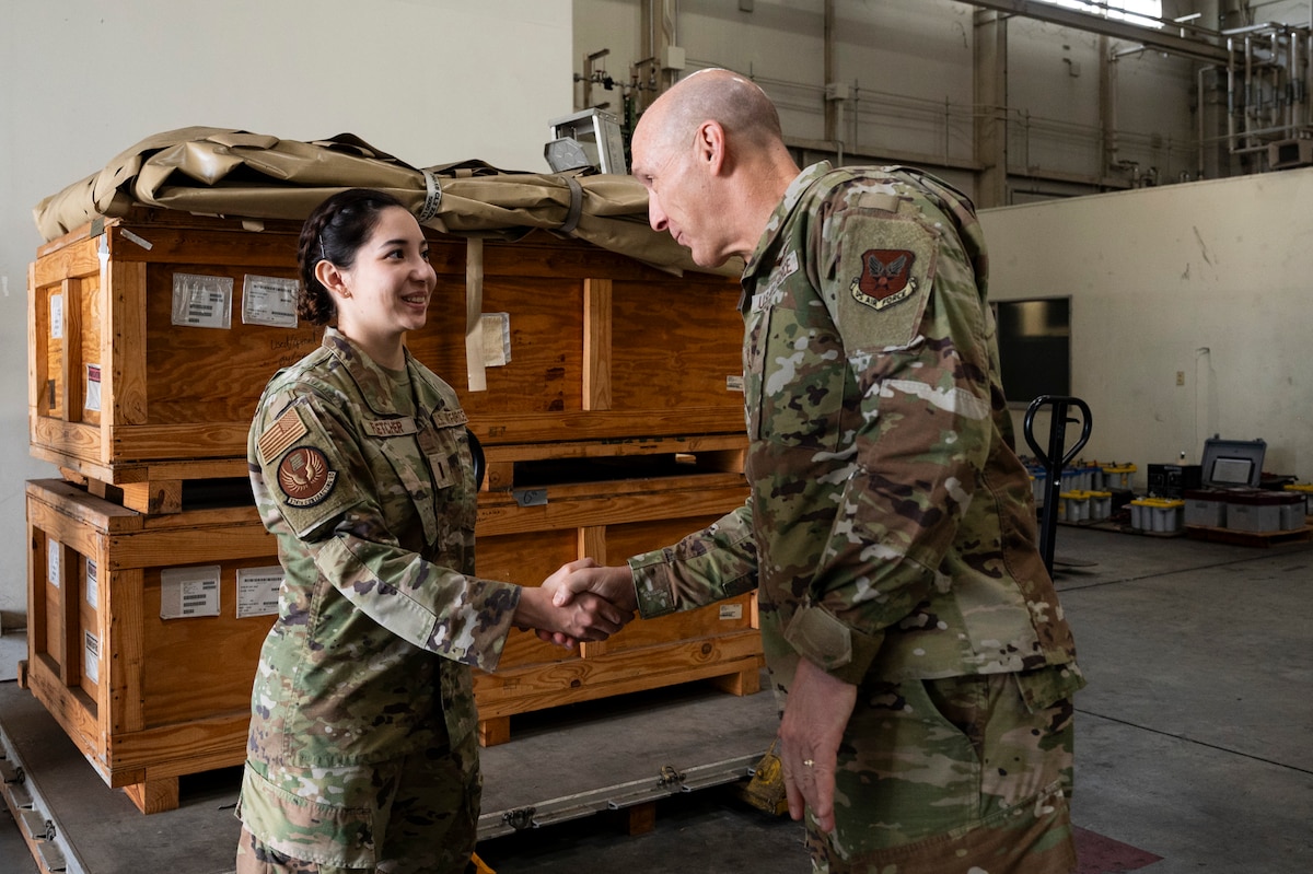 A military members shakes hands with another military member.