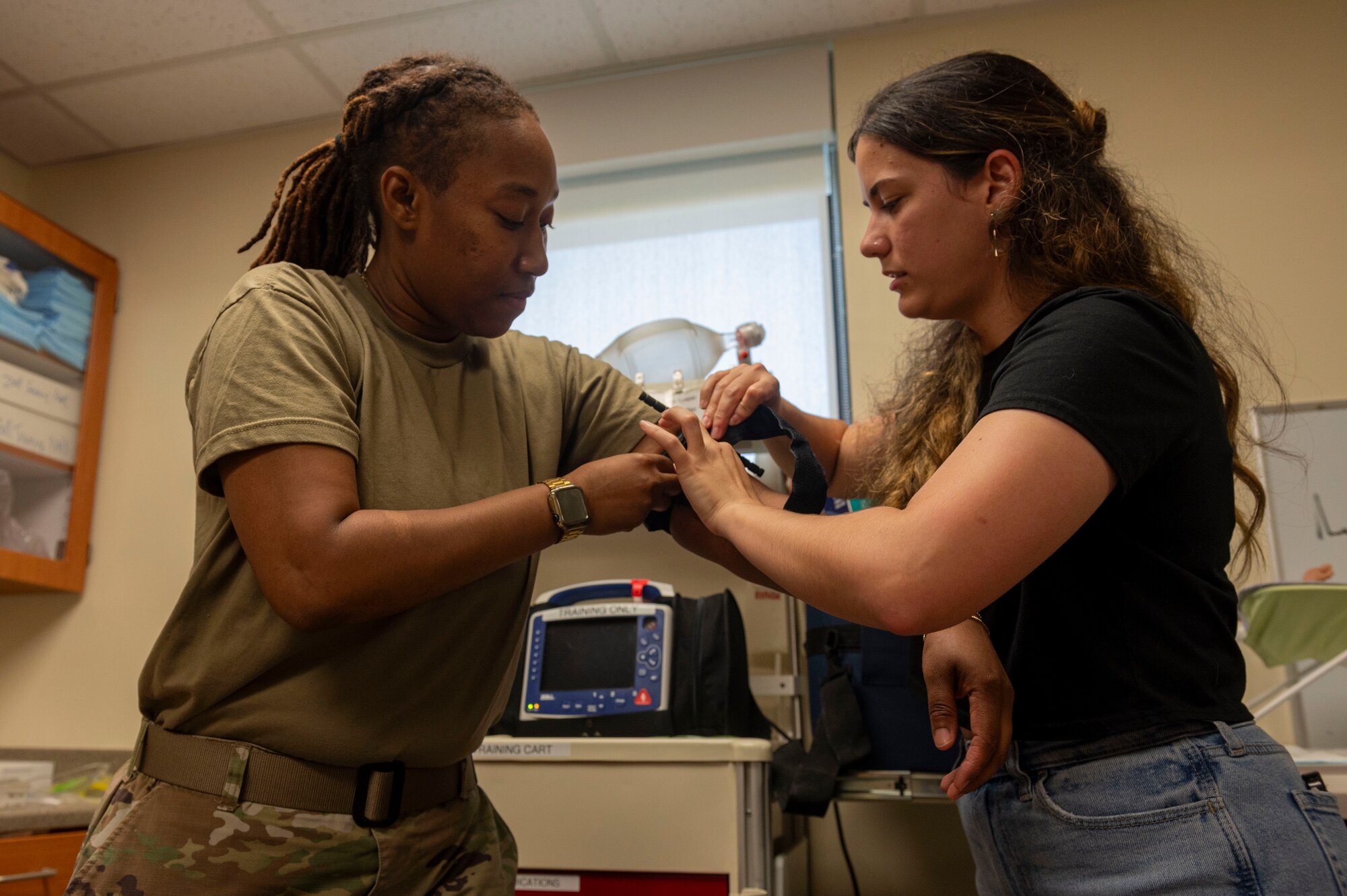 U.S. Air Force Staff Sgt. Tiffany Sims, 51st Medical Group tactical casualty care wing coordinator, teaches Ruth Ortega Varela, Osan spouse, how to apply a tourniquet during the Osan Spouse Immersion Tour at Osan Air Base, Republic of Korea, Oct. 16, 2024. The 51st MDG's mission is to maintain and ensure medical readiness for contingencies by providing high-quality, trusted care for approximately 8,000 enrollees and 20,000 beneficiaries. (U.S. Air Force photo by Senior Airman Kaitlin Frazier)