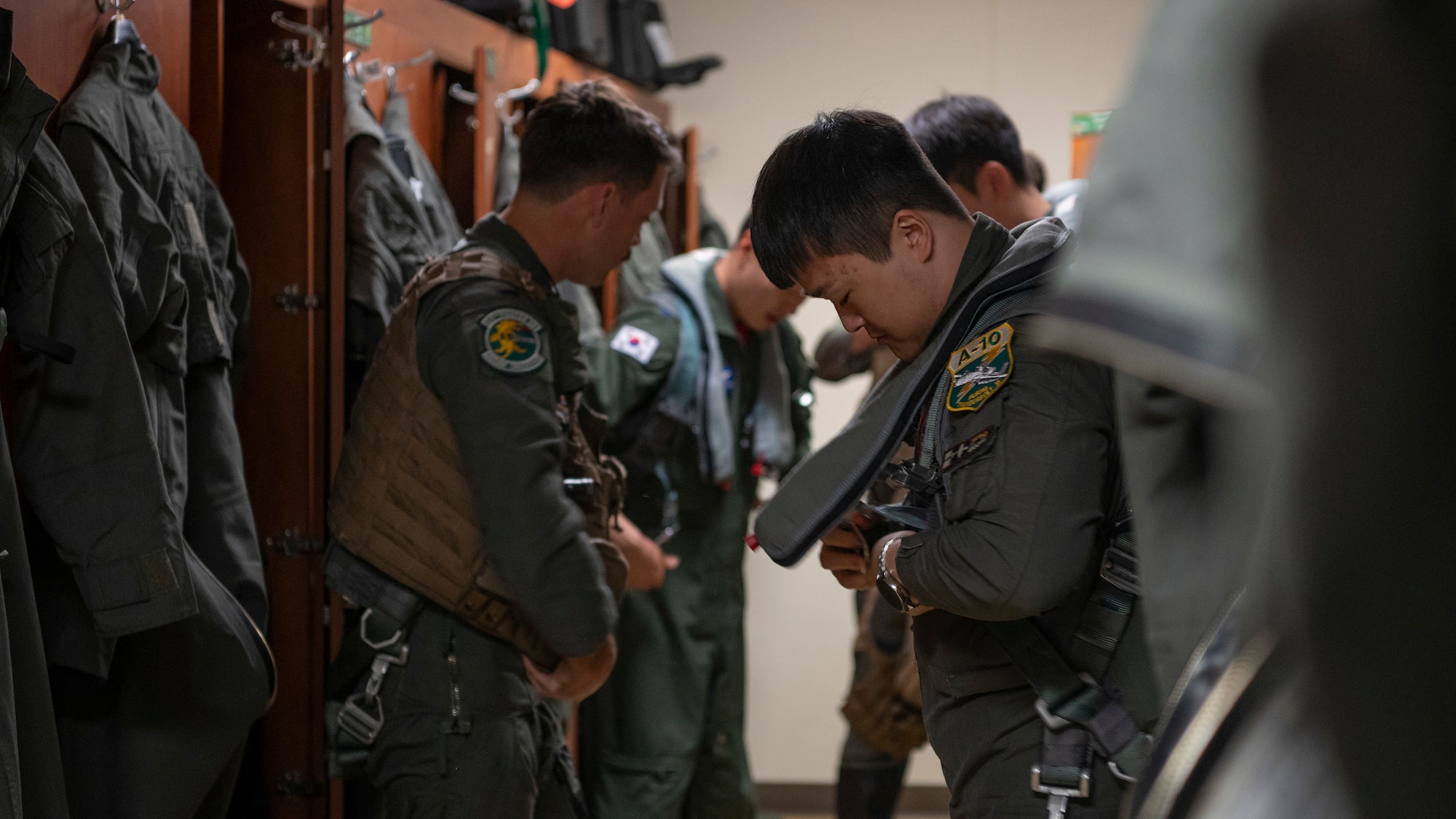 Republic of Korea Air Force pilots assigned to the 8th Fighter Wing out of Wonju Air Base, and U.S. Air Force pilots assigned to the 25th Fighter Squadron, gear up before mission briefs at Osan Air Base, ROK, Oct. 16, 2024. The units came together for their semi-annual Buddy Squadron event that allows ROKAF and U.S. Air Force pilots an opportunity to share and practice flying concepts and tactics. (U.S. Air Force photo by Staff Sgt. Ashley N. Mikaio)