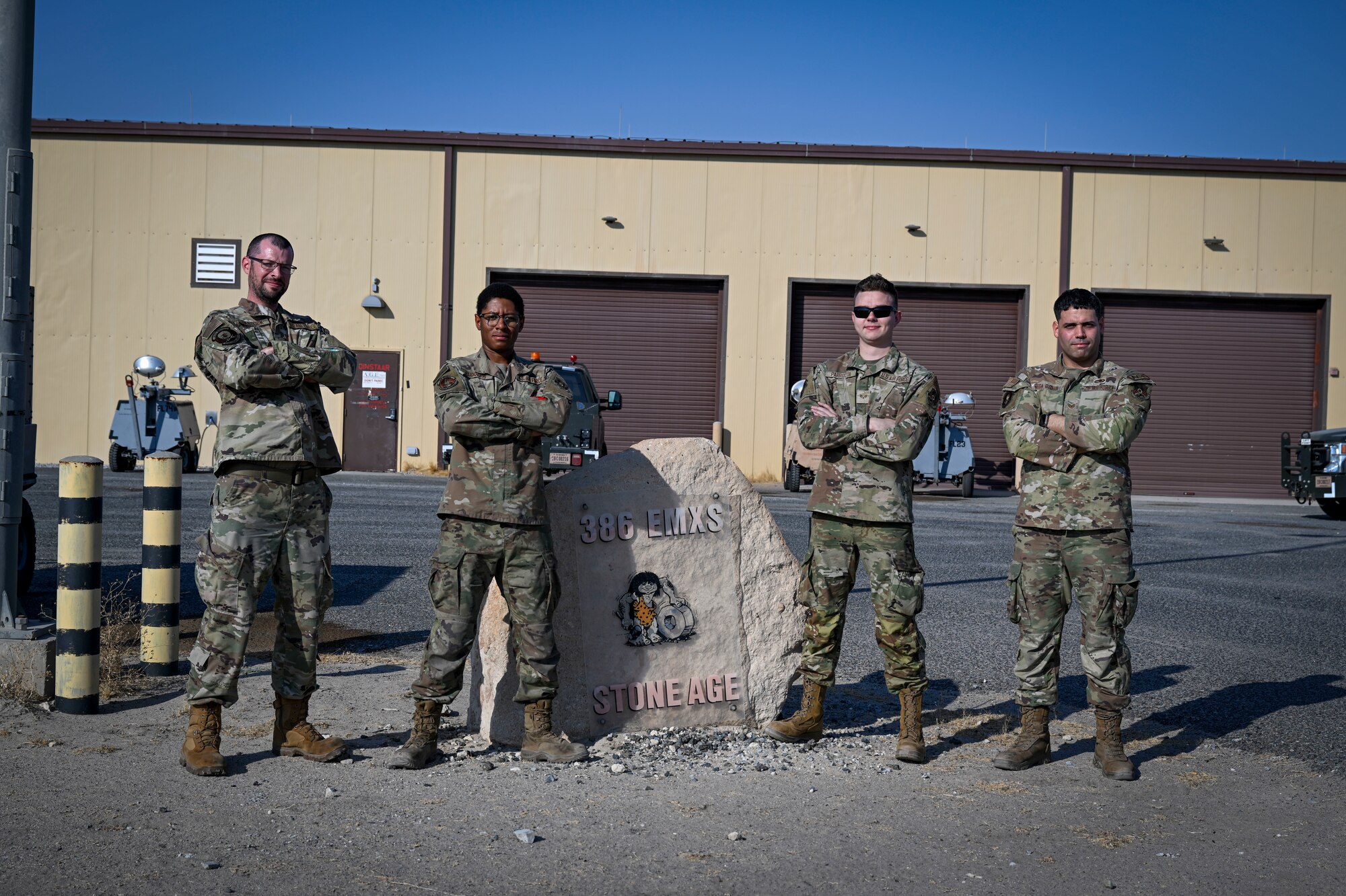 Four Airmen pose for a photos.