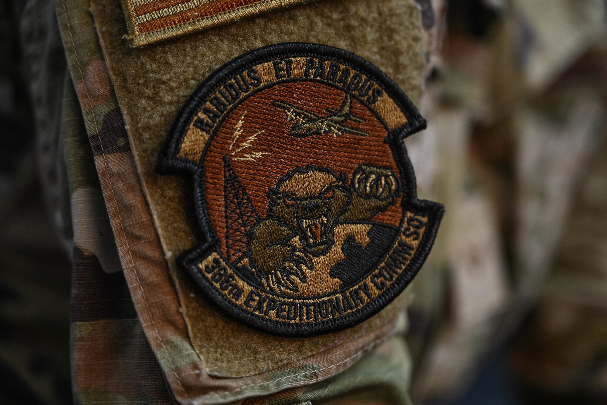 A patch with the words "rabidus et paradus" on the top of it, and "386th Expeditionary Comm Sq" on the bottom is worn by someone in uniform.