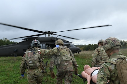 U.S. Army Sgt. Preston Clark, a flight medic with 12th Combat Aviation Brigade, accompanies Soldiers with the Headquarters and Headquarters Company, 56th Stryker Brigade Combat Team, Pennsylvania National Guard, as they transported a simulated wounded Soldier to an HH-60 Black Hawk helicopter during an air medevac exercise.