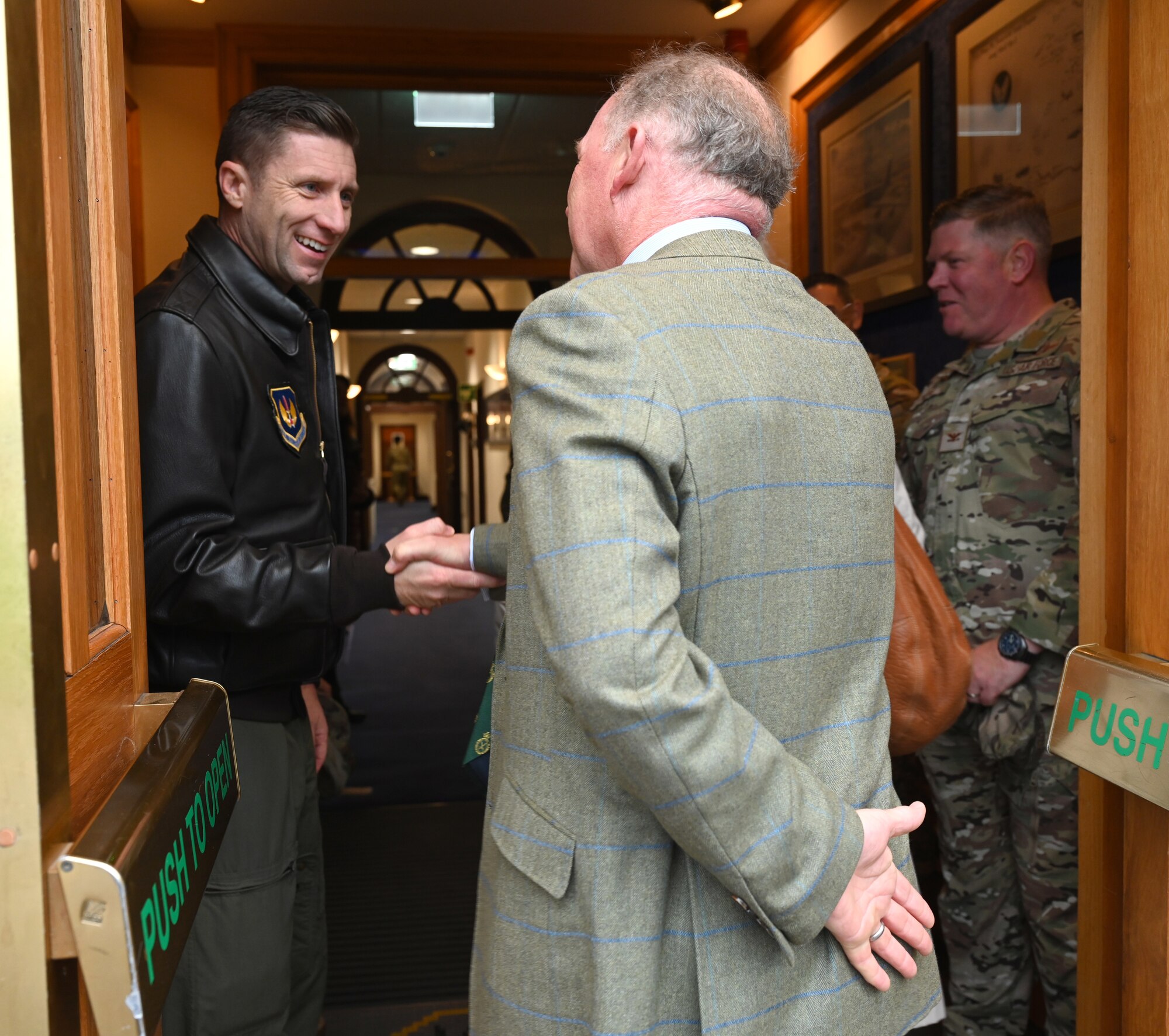 U.S. Air Force Col. Ryan Garlow, left, 100th Air Refueling Wing commander, greets David Flux, High Sheriff of Norfolk, before the start of a special event for Vice Lord-Lieutenants, Deputy Lieutenants, High Sheriffs, Royal Air Force representatives and other invited guests from the local community at Royal Air Force Mildenhall, England, Oct. 9, 2024. The event aimed to facilitate interactions between new appointees and base leadership, providing insights into the wing’s missions and showcasing various aircraft. (U.S. Air Force photo by Karen Abeyasekere)