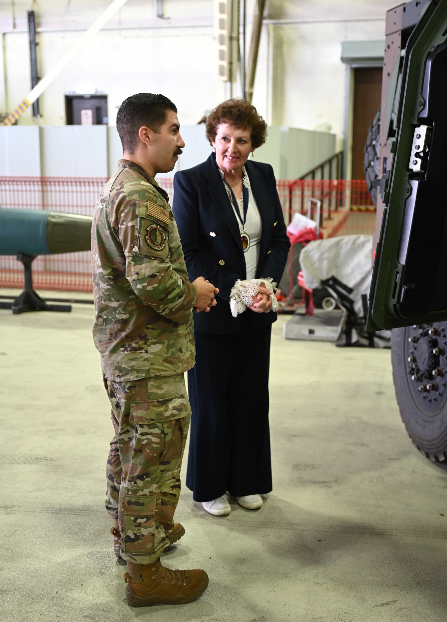 A U.S. Airman from the 48th Fighter Wing talks with Yvonne Gilchrist-Mann, High Sheriff of Suffolk, at a special event for Vice Lord-Lieutenants, Deputy Lieutenants, High Sheriffs, Royal Air Force representatives and other invited guests from the local community at RAF Lakenheath, England, Oct. 9, 2024. The event aimed to facilitate interactions between new appointees and base leadership, providing insights into the wing’s missions and showcasing various aircraft. (U.S. Air Force photo by Karen Abeyasekere)