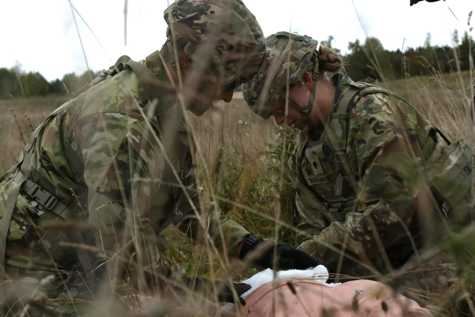 Spc. Christian Torres and Spc. Jazmyne Wanger tend to a simulated wounded soldier during an air medevac exercise at Grafenwoehr Training Area, Oct. 11, 2024. U.S. Army medics rehearse their evacuation procedures to stand ready to respond to real life medical emergencies. (U.S. Army National Guard photo by Capt. Leanne Demboski)