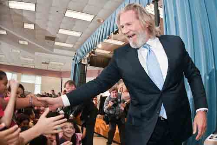 A man shakes a kid’s hand.