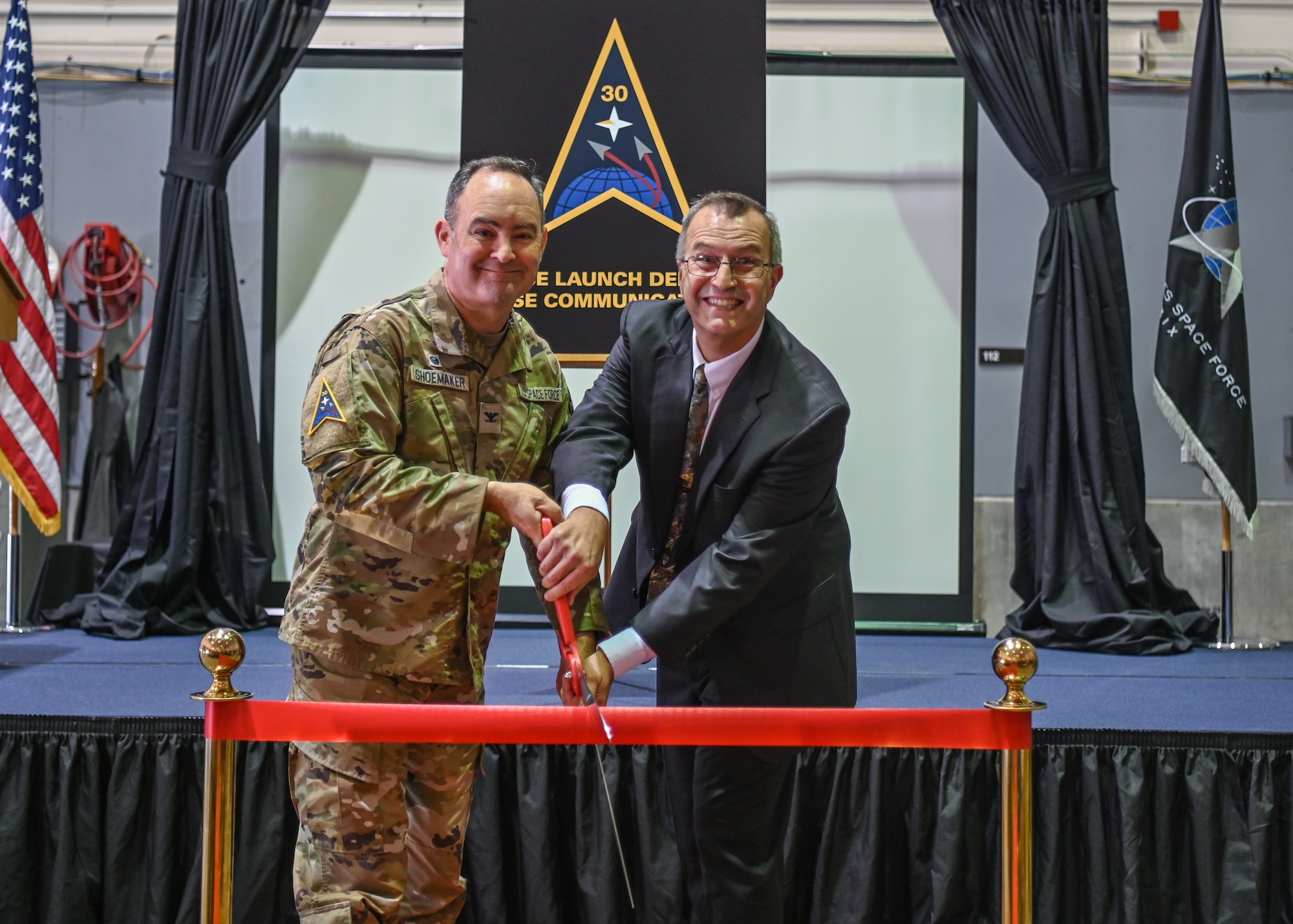 A Space Launch Delta 30 commander and a 30th Space Communications Directorate director, pose for a photo during a ribbon cutting at Vandenberg Space Force Base.