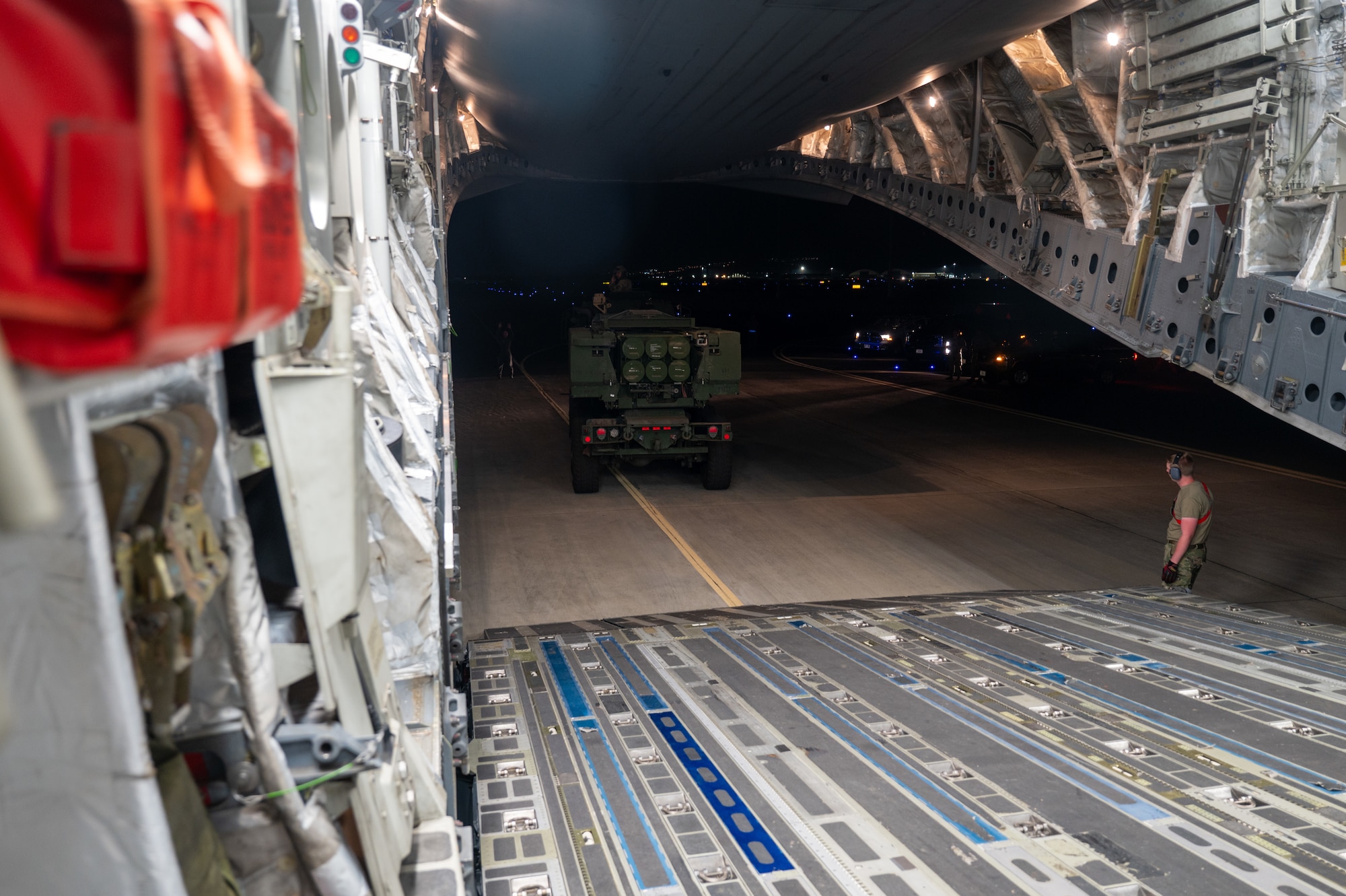 A High Mobility Artillery Rocket System vehicle reverses inside a C-17 Globemaster III aircraft.