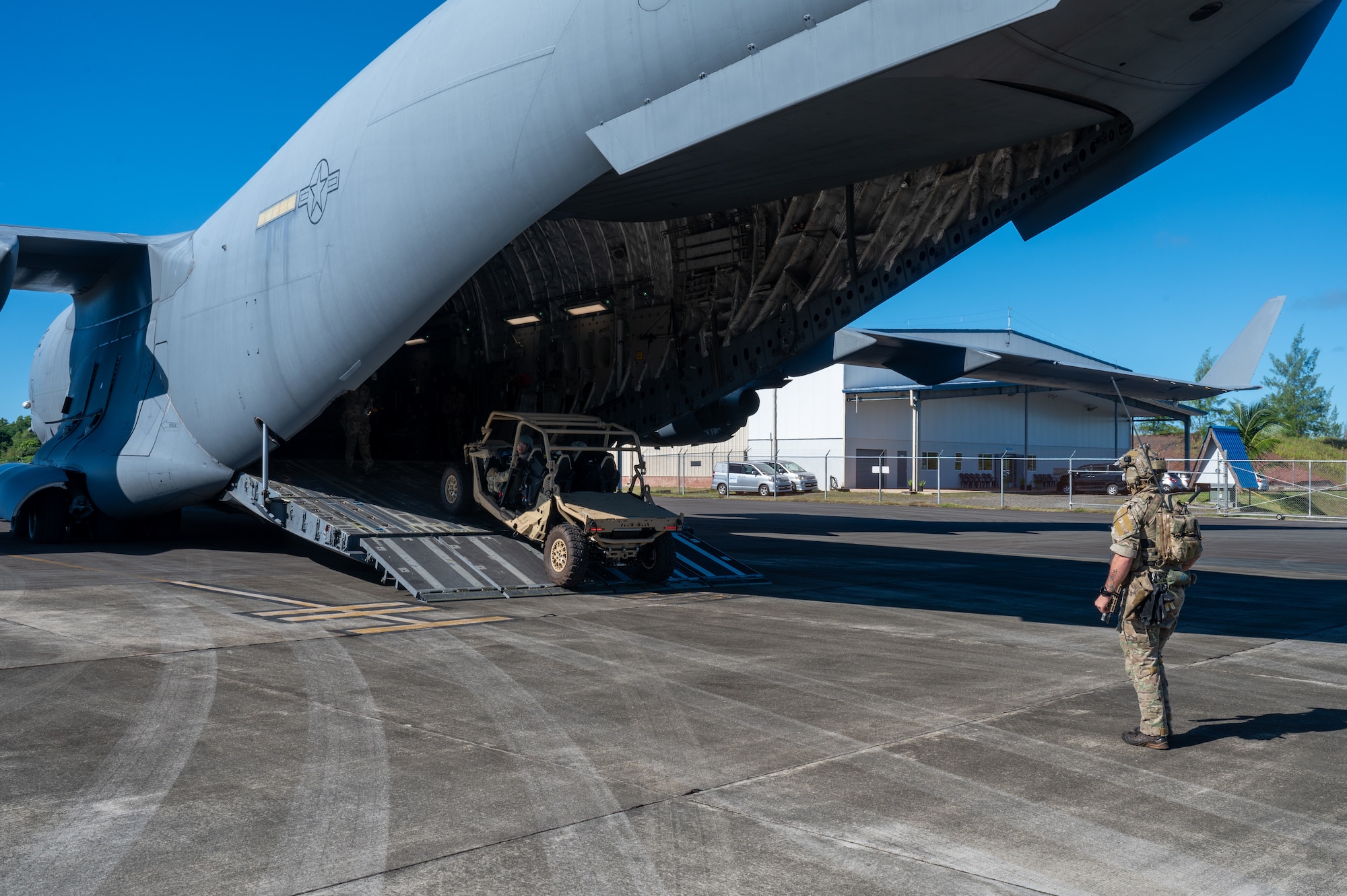 A U.S. Army Soldier guides a drive out of a C-17 Globemaster III aircraft.