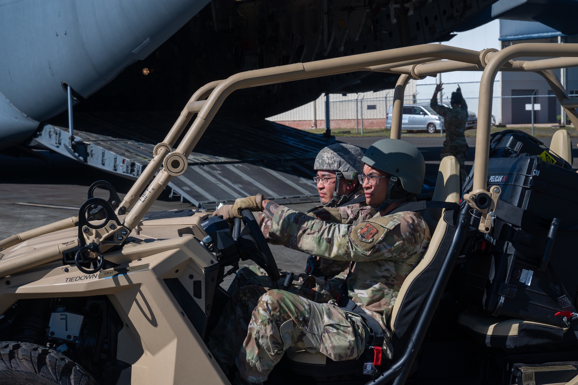 Two U.S. Space Force Airmen drive an all terrian vehicle.