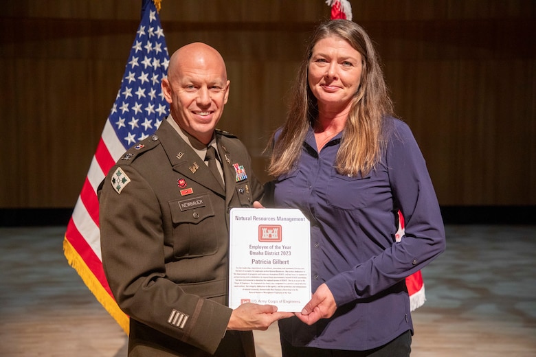 Patricia Gilbert (right), U.S. Army Corps of Engineers, Omaha District member, poses with Col. Robert Newbauer, commander, and her award after being named the Natural Resources Management Employee of the Year during an award ceremony, Oct. 17, 2024, at the Holland Performing Arts Center in Omaha, Nebraska.