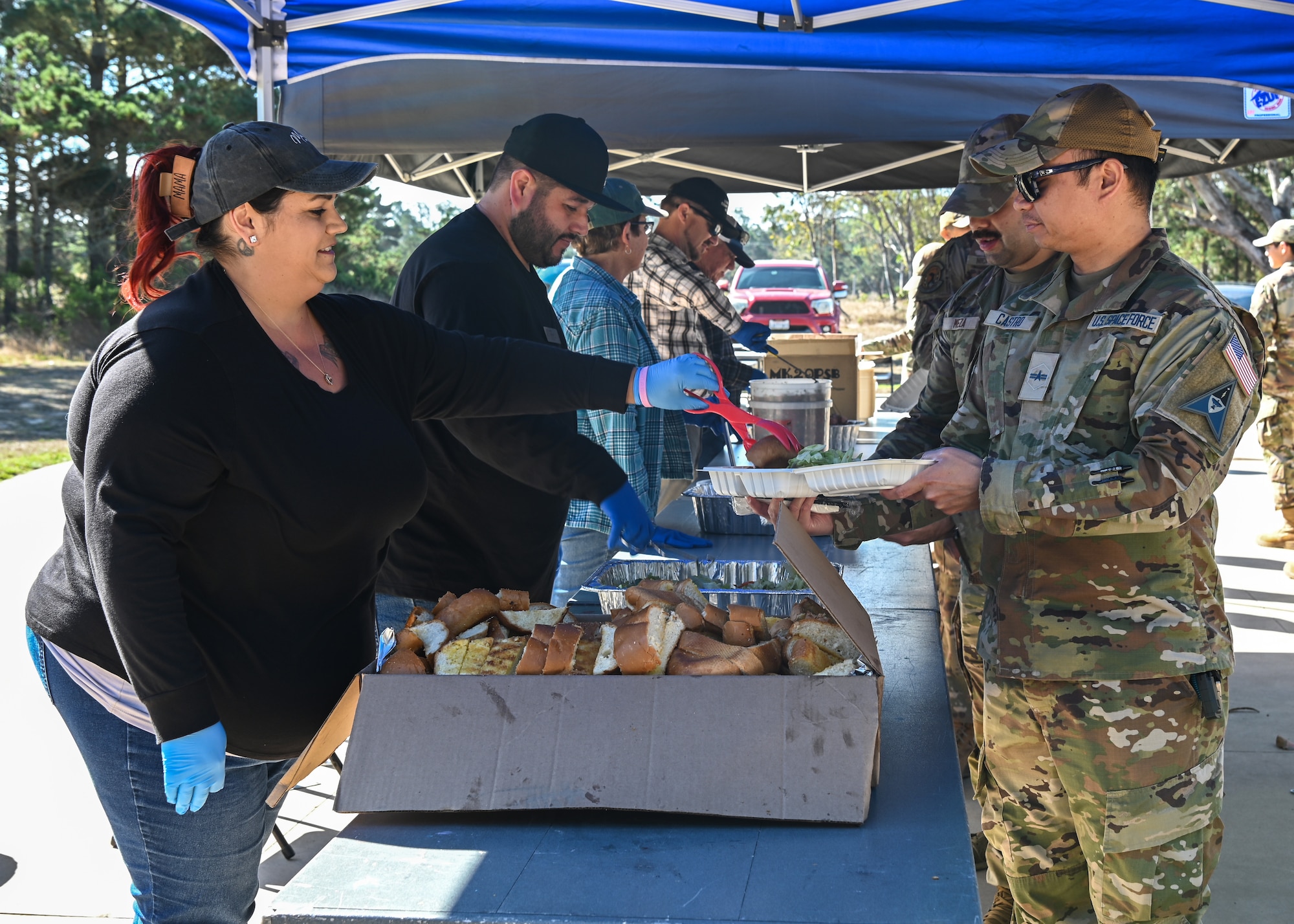 Guardians and Airmen wait in line to receive food during an annual Military Appreciation BBQ celebration at Vandenberg Space Force Base.