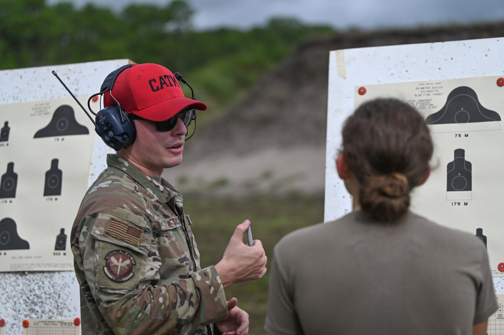 U.S. Air Force Senior Airman Logan Ramey, a 1st Special Operations Wing, Combat Arms Training and Maintenance Instructor, reviews an Airman's target at the CATM Range, Hurlburt Field, Florida, Sept. 25, 2024.