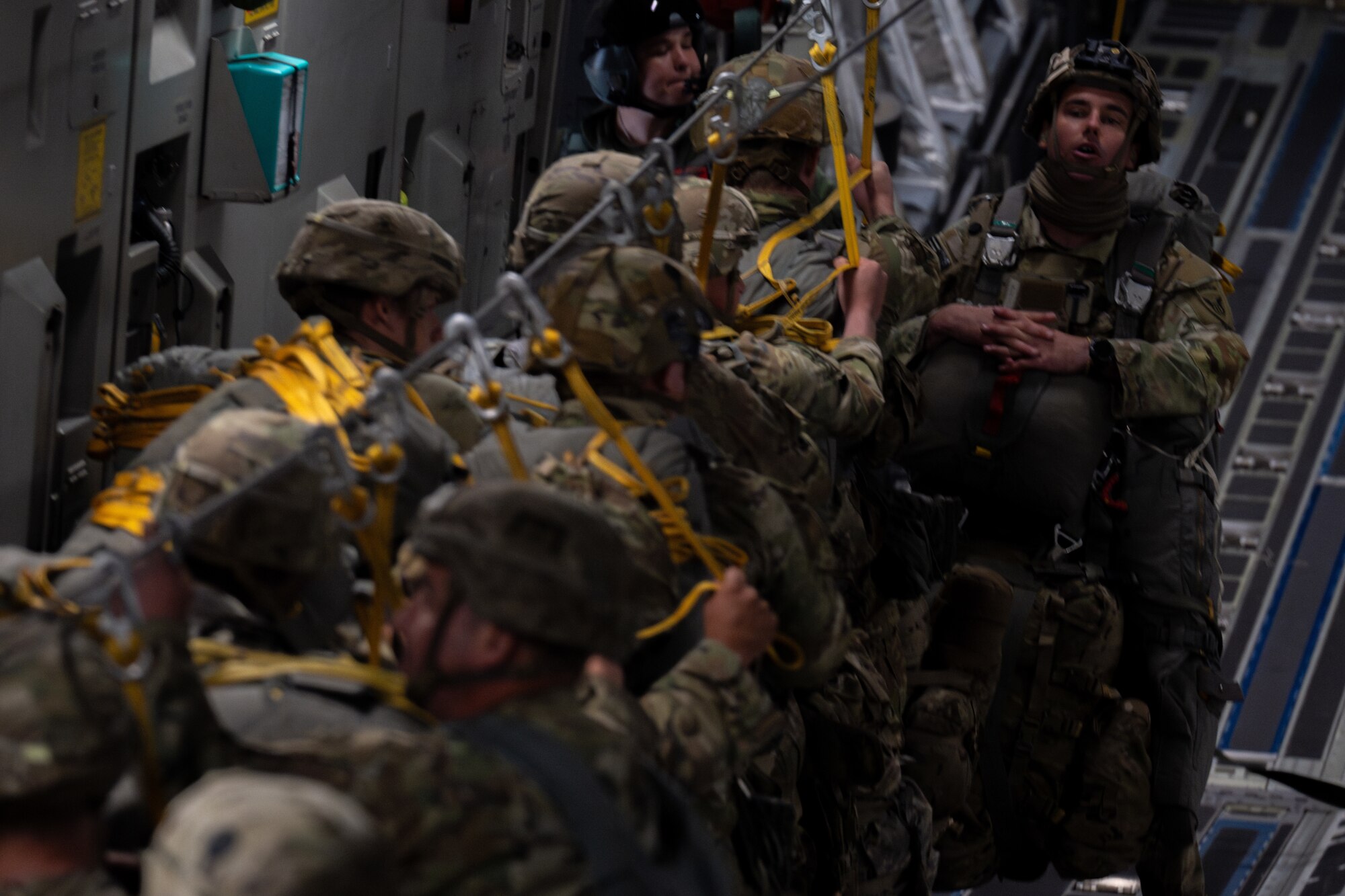 A line of soldiers wait to jump out of an aircraft.