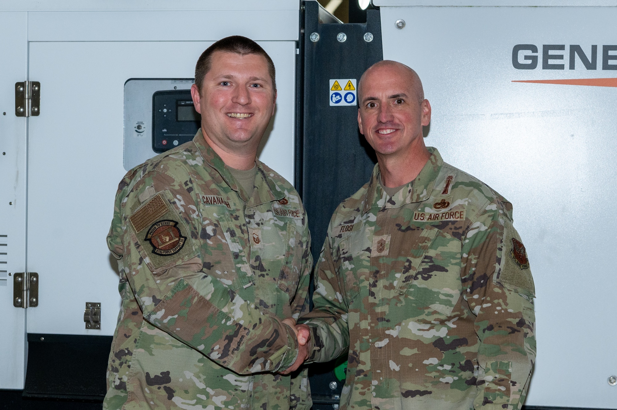 Chief Master Sgt. of the Air Force David Flosi coins Master Sgt. Nicholas Cavanaugh, section chief of career development, 673d Force Support Squadron, at Joint Base Elmendorf-Richardson, Alaska, Oct. 17, 2024.