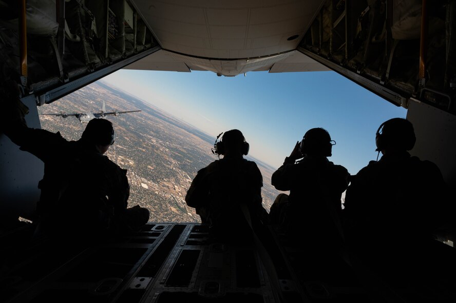 U.S. Air Force special mission aviators, assigned to the 15th Special Operations Squadron, and crew chiefs, assigned to the 15th Special Operations Maintenance Squadron, sit on the ramp of an MC-130J Combat Talon II during a flight over the United States Air Force Academy, Colorado, Oct. 5, 2024.