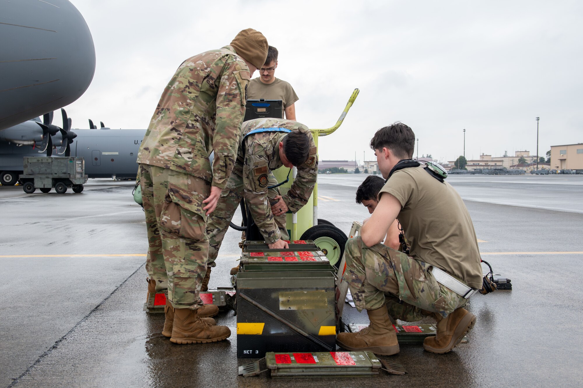 Several Airmen gather around a box of chaff and flares.