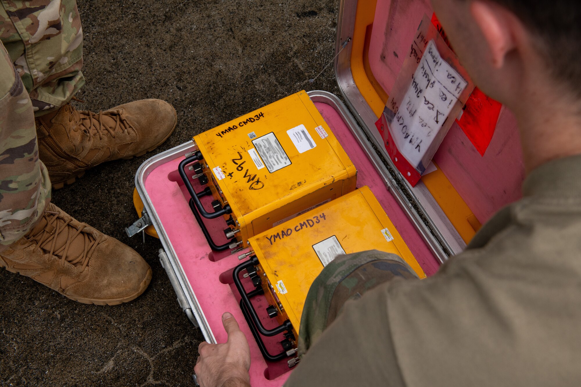 Airmen look at fuses in a container