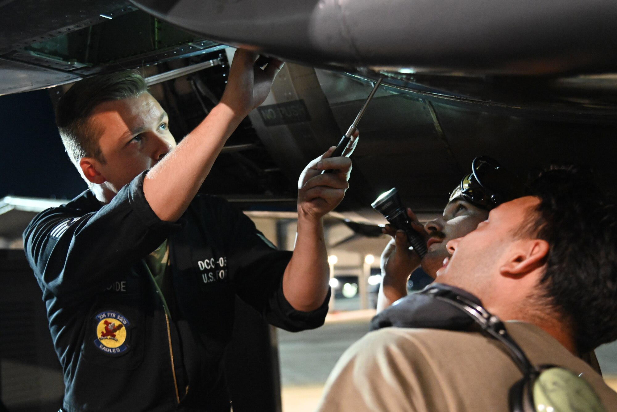 Airmen perform maintenance on an F-15E Strike Eagle.