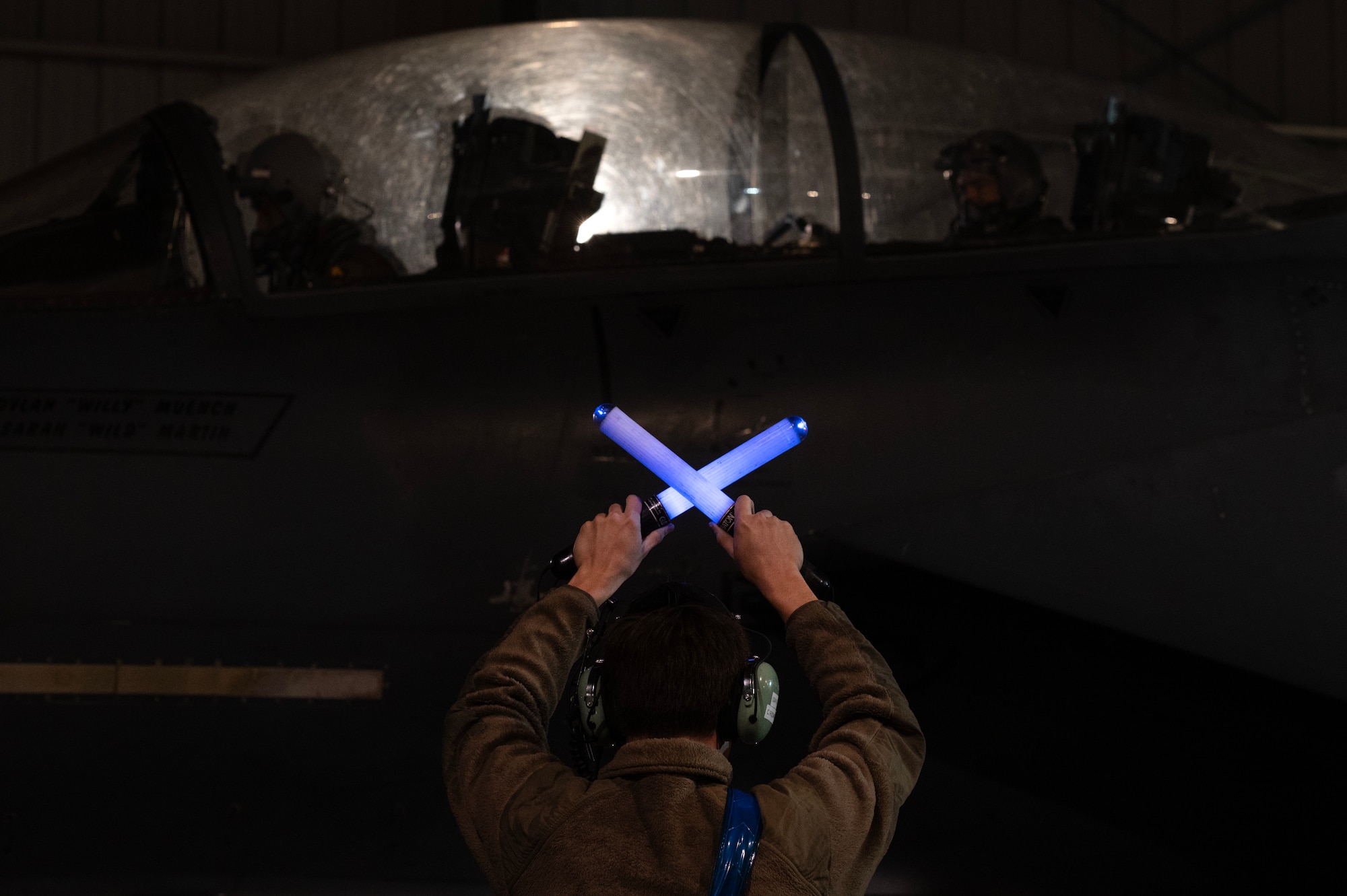 A1C Rudan, 334th Fighter Generation Squadron assistant dedicated crew chief, marshals an F-15E Strike Eagle.