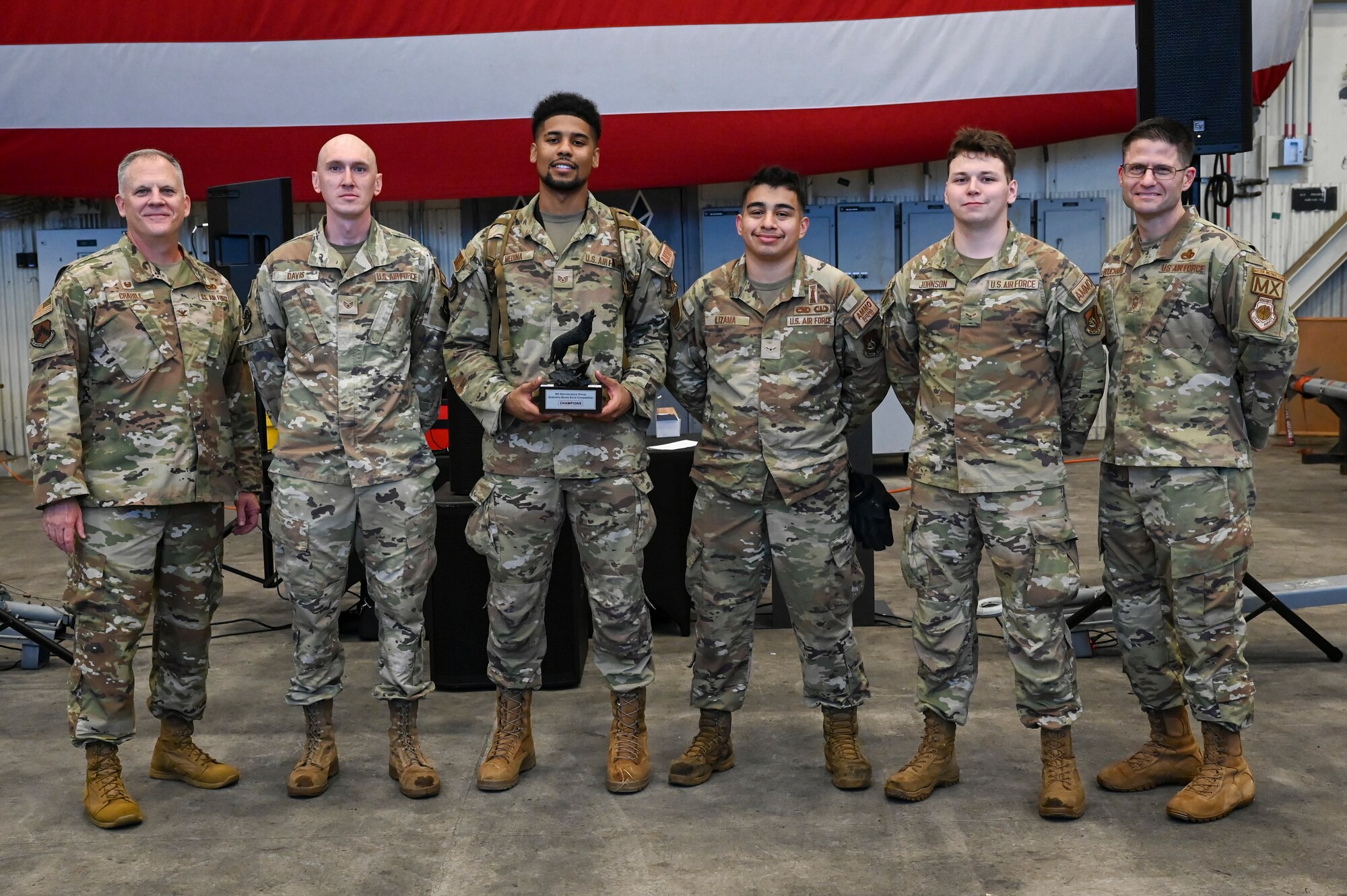 U.S. Air Force Col. Casey Crabill, far left, 8th Maintenance Group commander, and Chief Master Sgt. Nathan Bouchard, far right, 8th MXG command chief, congratulate the winners of the bomb building portion of the 2024 3rd Quarter Dedicated Crew Chief and Load Crew Competition.