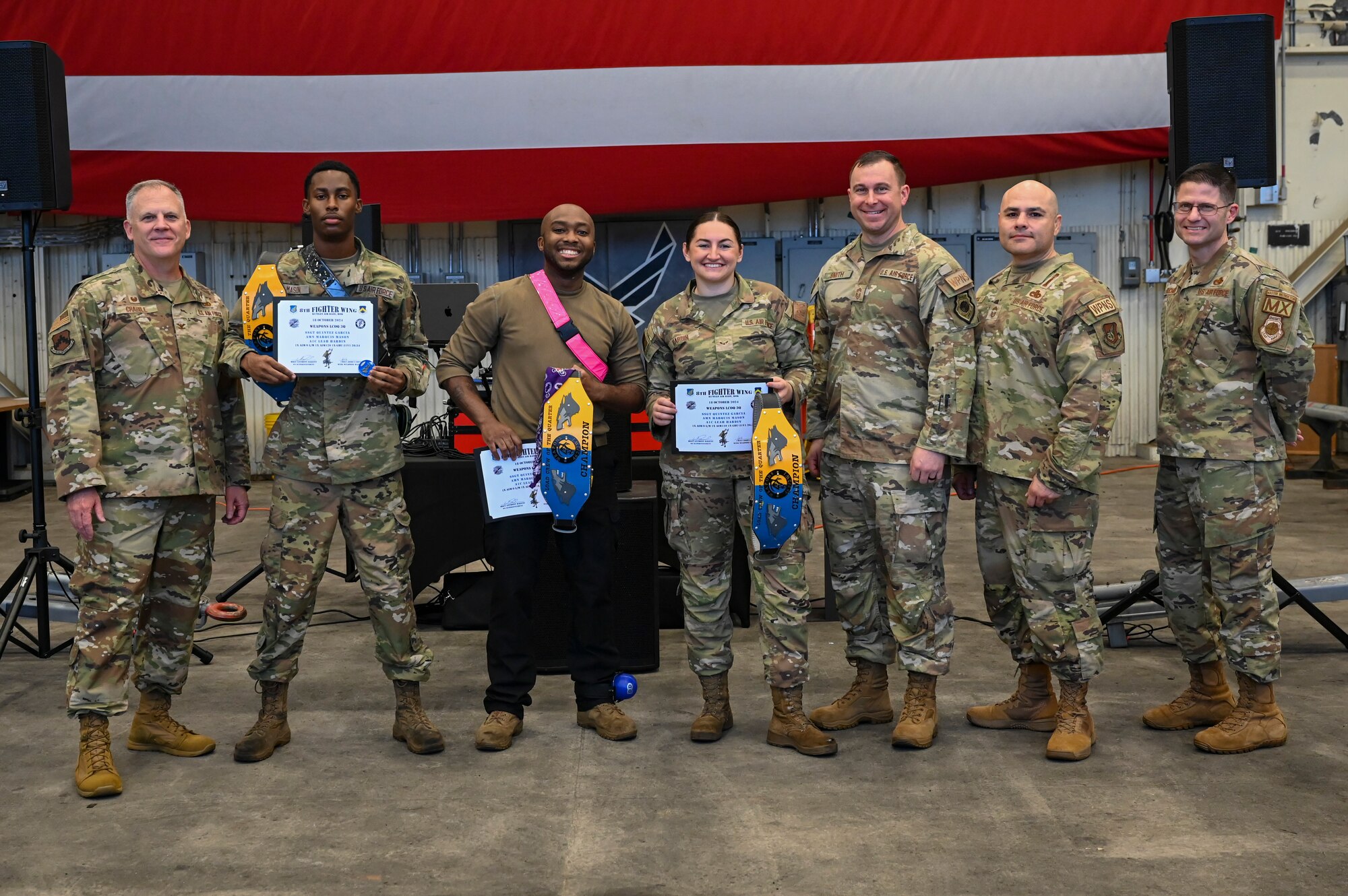U.S. Air Force Col. Casey Crabill, far left, 8th Maintenance Group commander, and Chief Master Sgt. Nathan Bouchard, far right, 8th MXG command chief, award the winners of the load crew team of the quarter during the 2024 3rd Quarter Dedicated Crew Chief and Load Crew Competition.