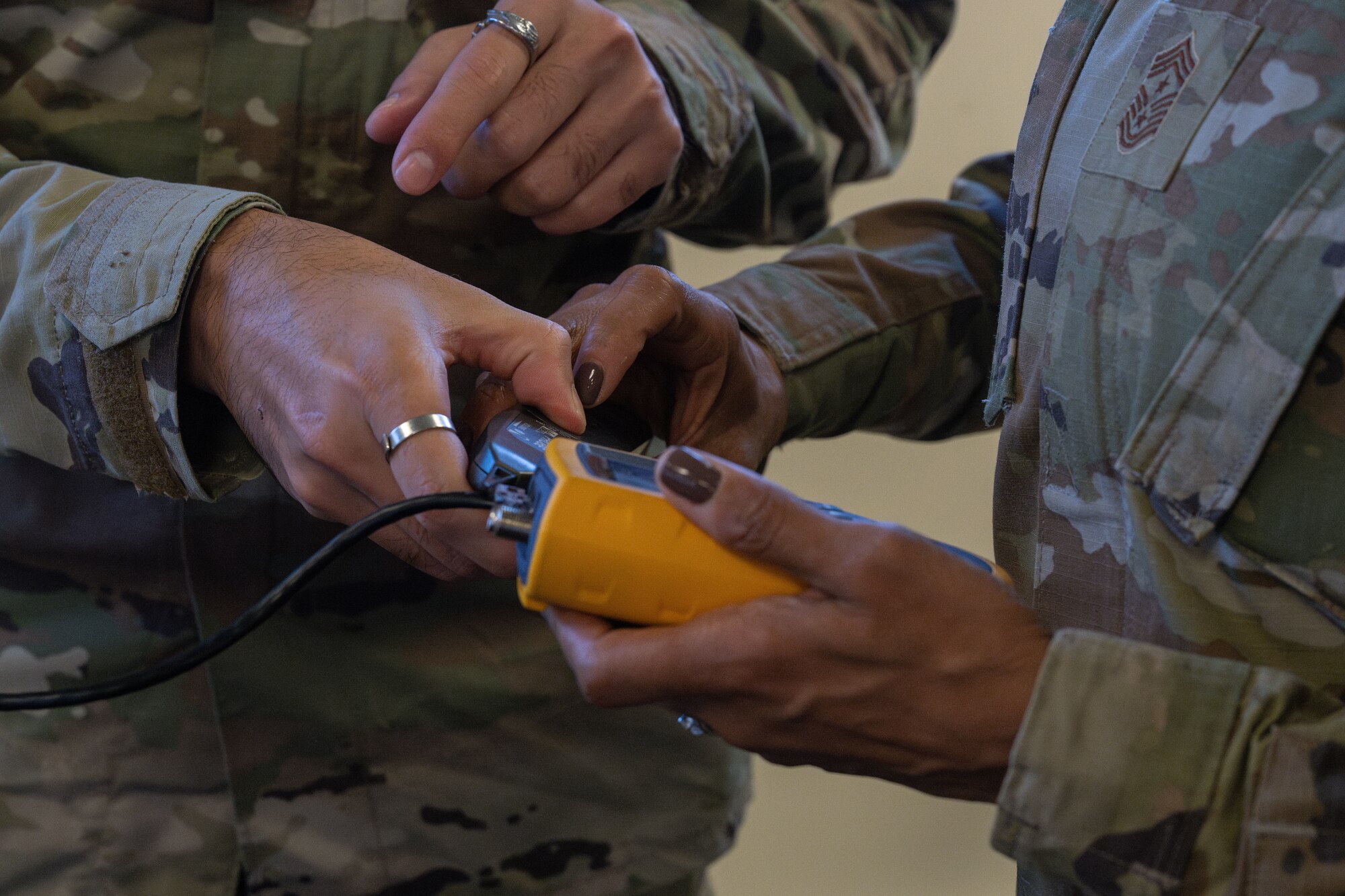 U.S. Air Force Airman 1st Class Hashmat Alikozay, left, 100th Communications Squadron network system technician, shows Chief Master Sgt. Tiffany Griego, 100th Air Refueling Wing command chief, how to set up a tone generator during a “Day in the Life” integration with the 100th CS at Royal Air Force Mildenhall, England, Oct. 18, 2024.