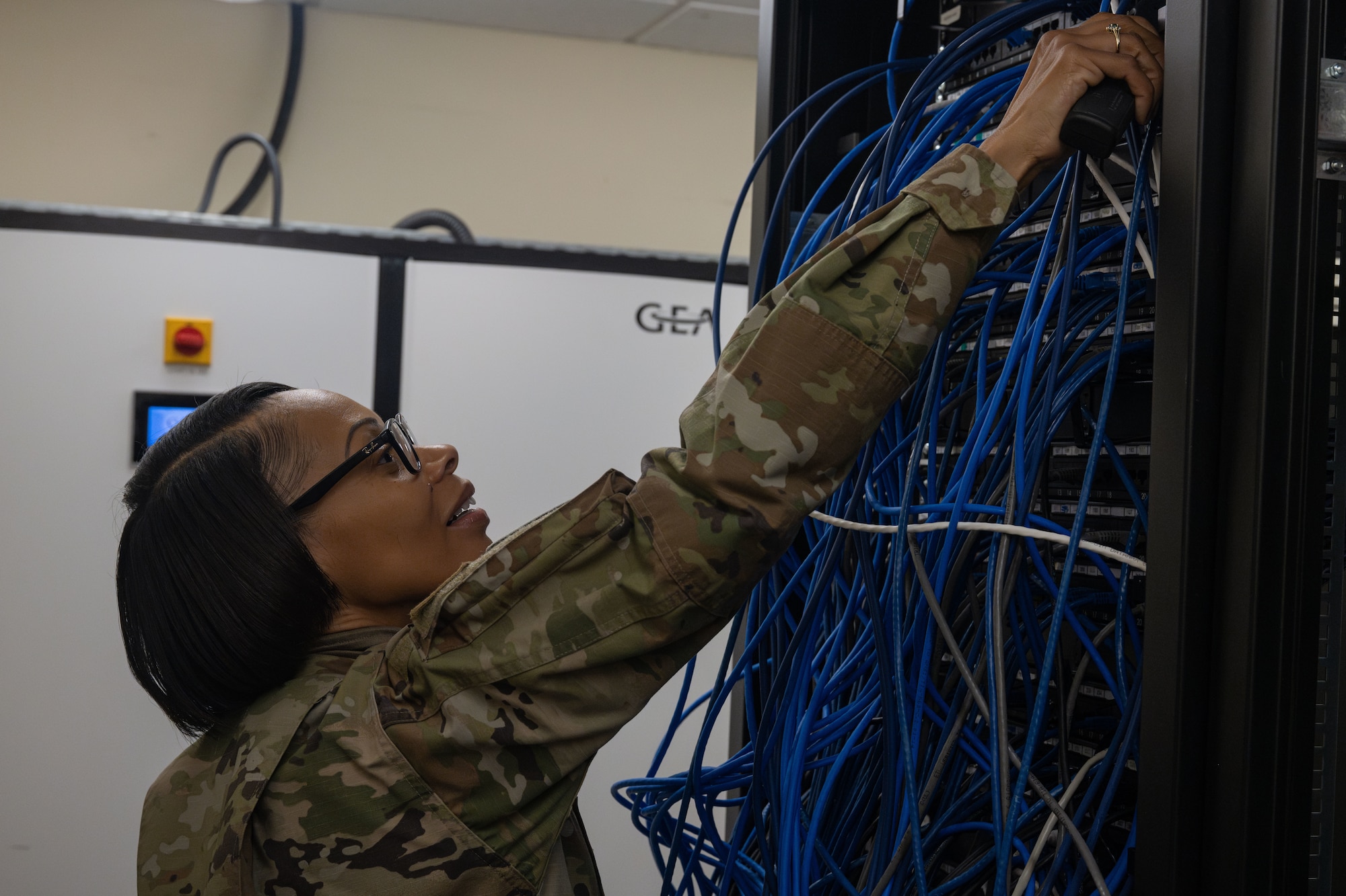 U.S. Air Force Chief Master Sgt. Tiffany Griego, 100th Air Refueling Wing command chief, uses the tone generator to locate a communications port during a “Day in the Life” integration with the 100th CS at Royal Air Force Mildenhall, England, Oct. 18, 2024.