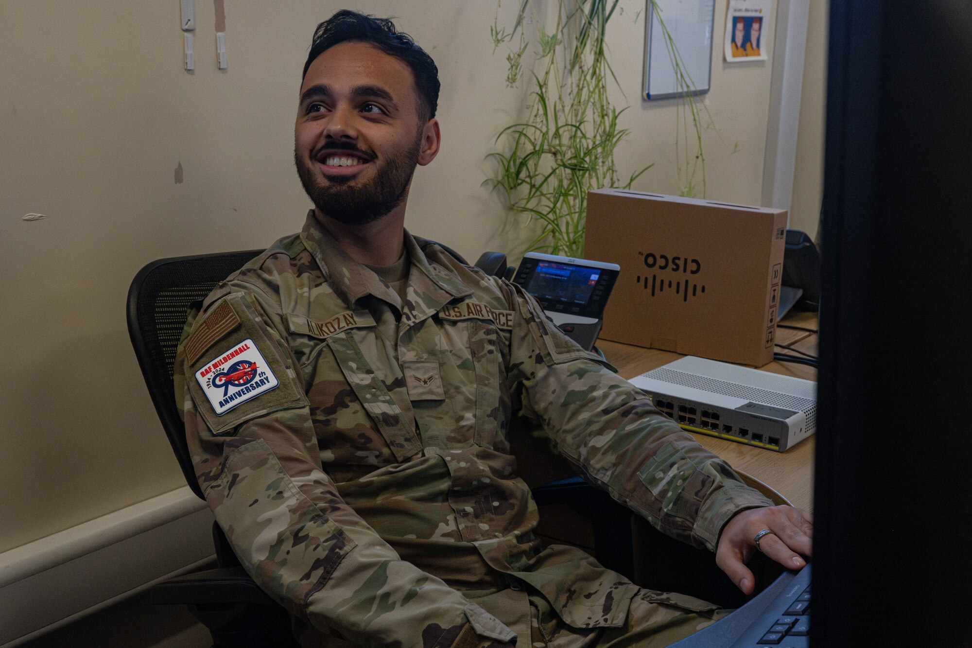 U.S. Air Force Airman 1st Class Hashmat Alikozay, 100th Communications Squadron network system technician, explains to the command team how to set up a Voice Over Internet Protocol phone during a “Day in the Life” integration with the 100th CS at Royal Air Force Mildenhall, England, Oct. 18, 2024.
