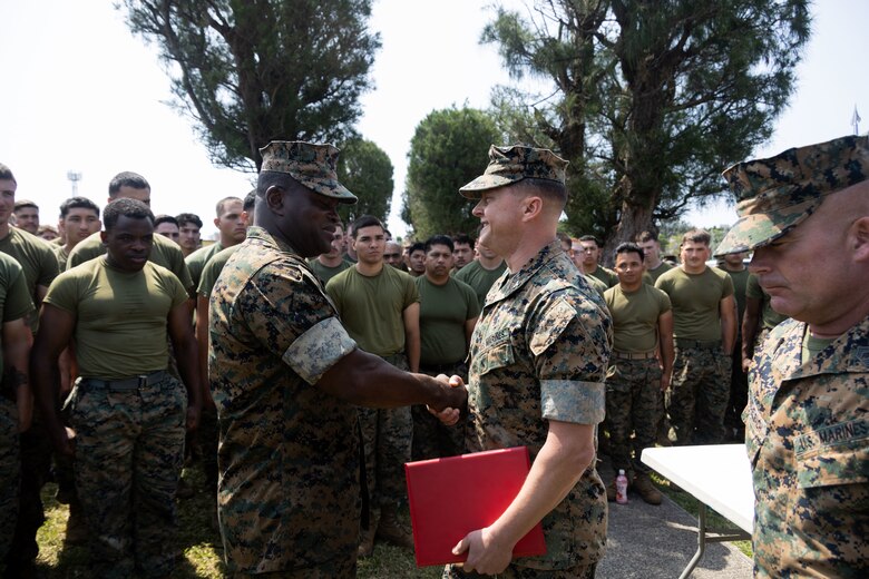 U.S. Marine Corps Sgt. Maj. Ismael Bamba, left, is awarded the Navy and Marine Corps Commendation Medal by Col. Peter Eltringham, middle, on Camp Hansen, Okinawa, Japan, April 11, 2024. Bamba received the award for his heroic actions that saved the life of a Japanese national in Okinawa, Japan. The Navy and Marine Corps Commendation Medal is awarded to Marines and Sailors for meritorious service or acts of heroism. Bamba, a native of Ivory coast, West Africa, is the sergeant major and Eltringham, a native of Rhode Island, is the commanding officer, both with of 12th Marine Regiment, 3d Marine Division.
