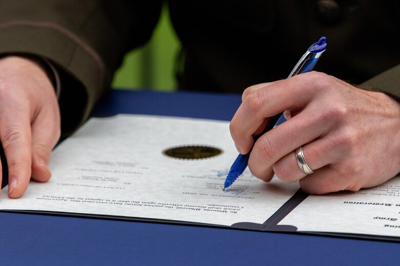A man signs a document.
