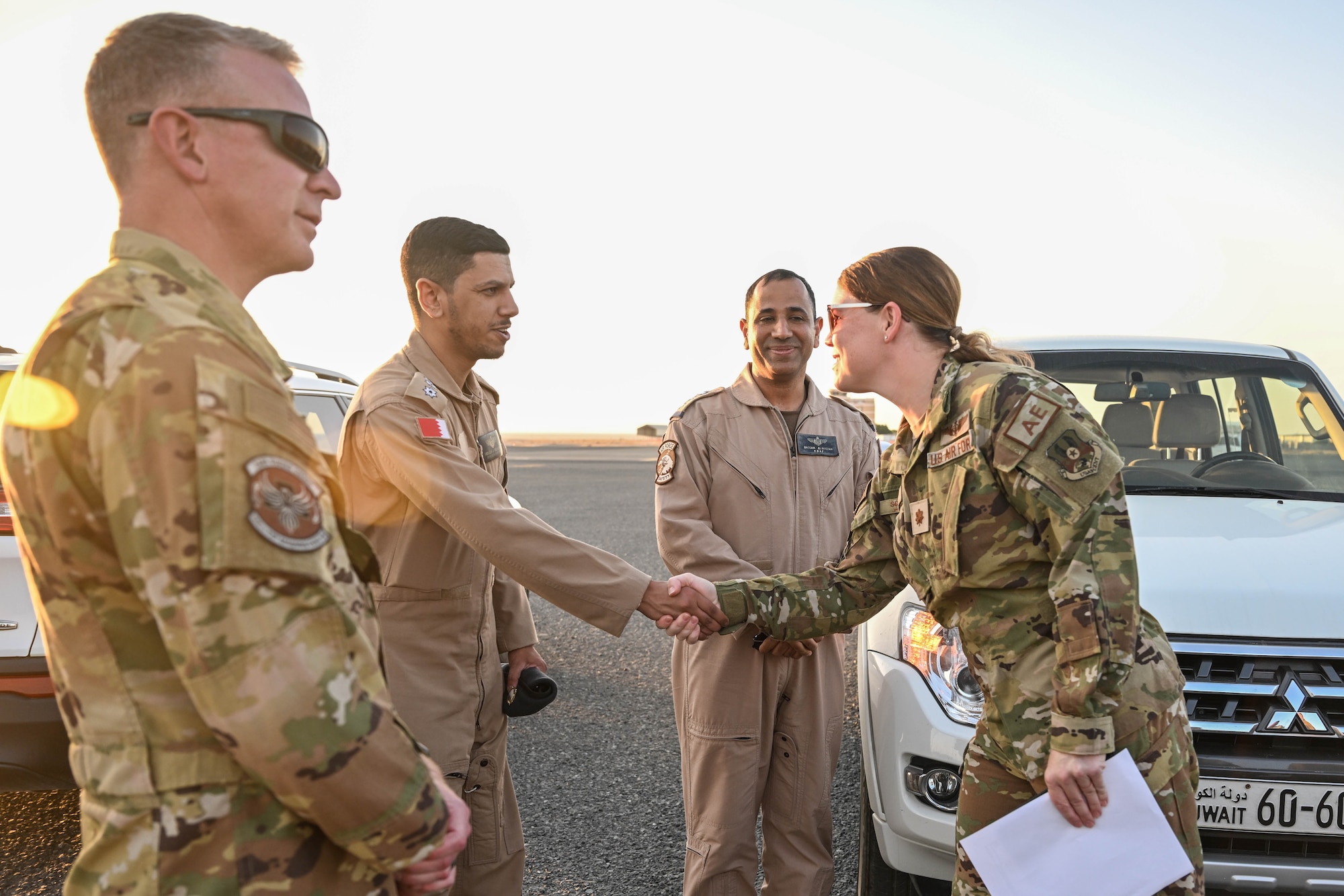 Two people shake hands while two others stand next to them.