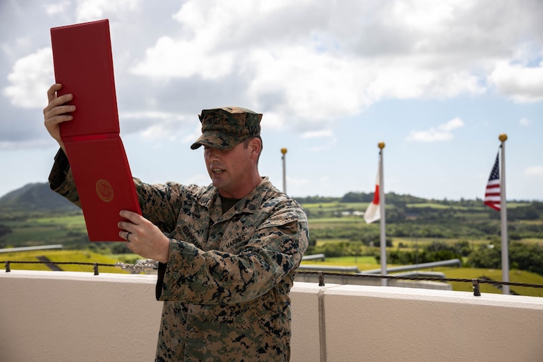 U.S. Marine Corps Staff Sgt. Jack Kemppainen, a transmissions chief with 12th Marine Littoral Regiment, 3d Marine Division reads a promotion warrant while conducting a promotion ceremony during exercise Resolute Dragon 24 at Japan Ground Self-Defense Force Camp Ishigaki, Okinawa, Japan, Aug. 1, 2024. Cpl. Lee is the first Marine to be promoted into the noncommissioned officer ranks on JGSDF Camp Ishigaki. Lee’s responsibilities as a corporal in his military occupational specialty range from ensuring the technical and tactical proficiency of his subordinates to the management of more than $600,000 worth of communications gear. RD 24 is an annual bilateral exercise in Japan that strengthens the command, control, and multi-domain maneuver capabilities of U.S. Marines in III Marine Expeditionary Force and Japan Self-Defense Force personnel, with a focus on controlling and defending key maritime terrain. Kemppainen is a native of Montana. Lee is a native of Alaska.