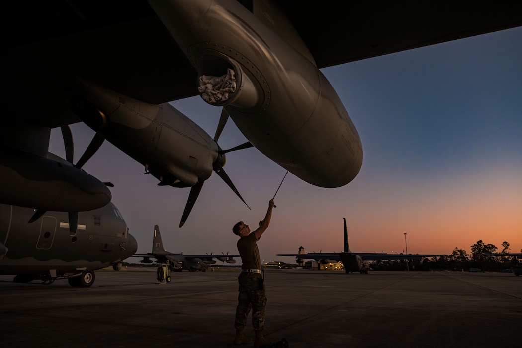 An Airman woks on a 130 on the flight line