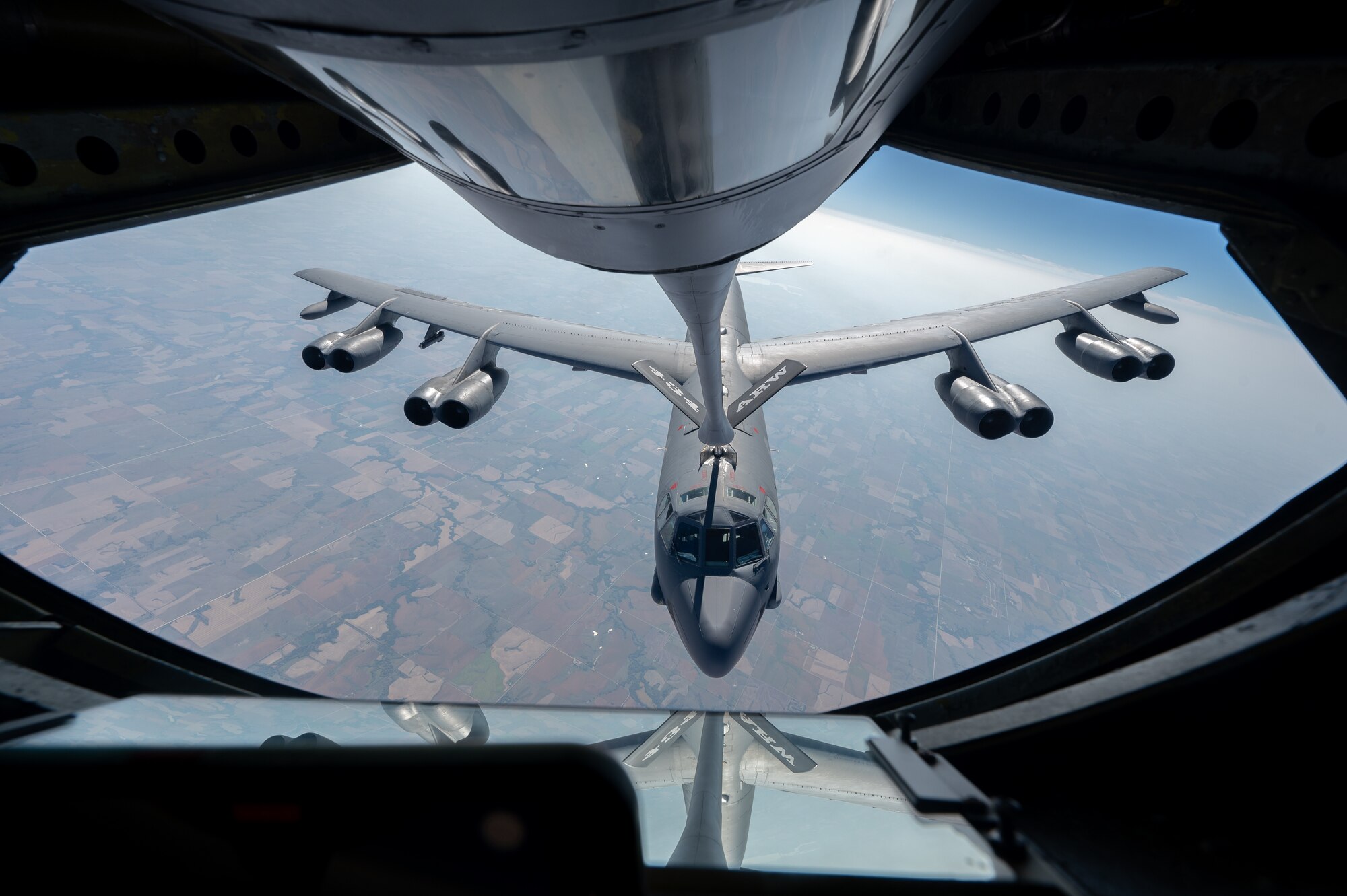 A large military aircraft receives fuel, while in flight, from another military aircraft.