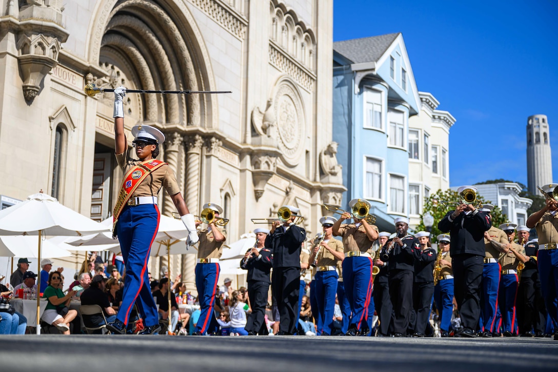 Marine Corps and Navy band members play instruments while marching in the parade.