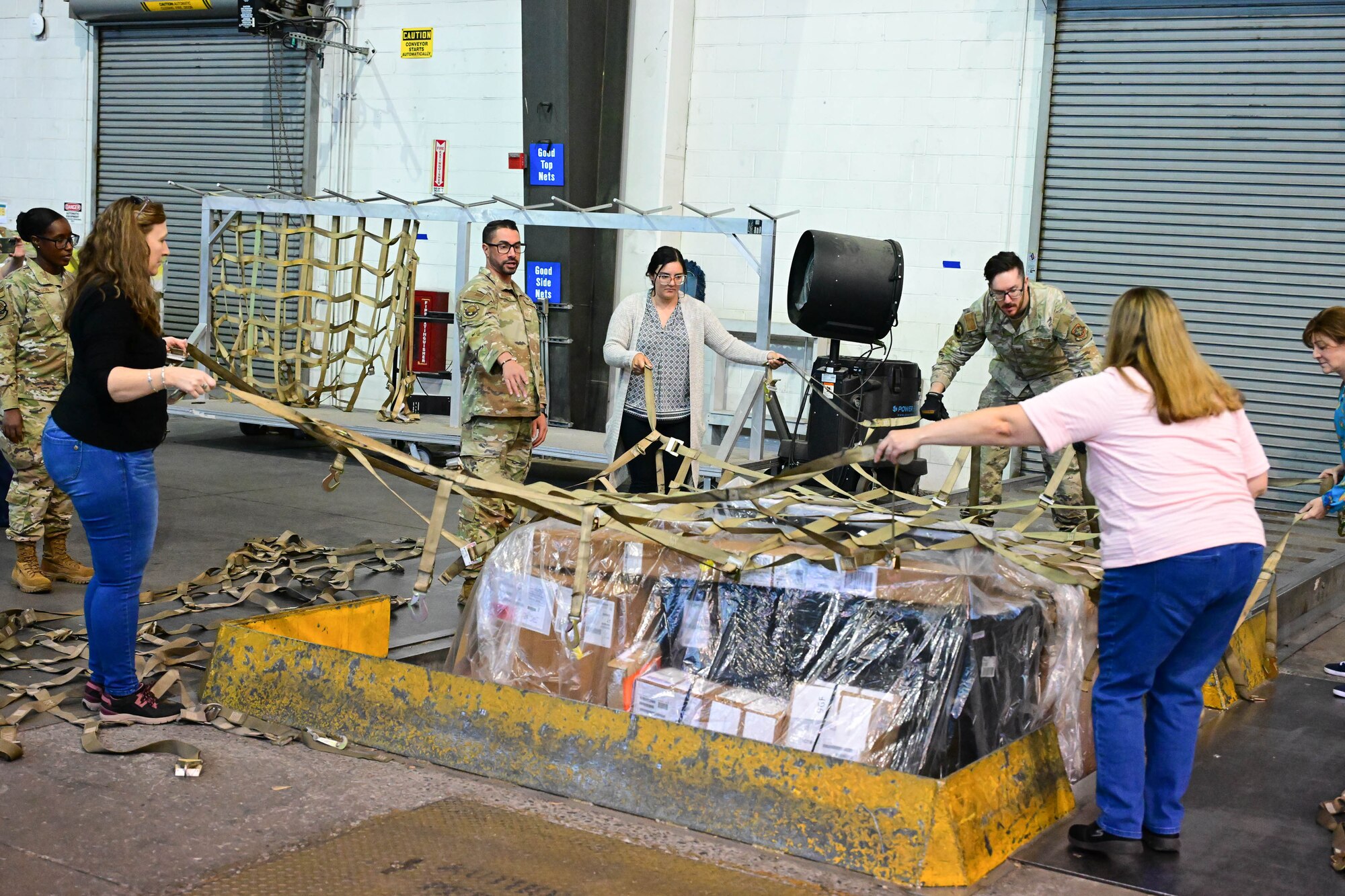 U.S. Air Force Tech. Sgt. Salvatore Persico, 436th Aerial Port Squadron noncommissioned officer in charge of cargo processing, shows Delaware Municipal Electric Corporation staff how to build a pallet of cargo at Dover Air Force Base, Delaware, Oct. 21, 2024. Team Dover provided the DEMEC staff a hands-on tour to familiarize them with the base mission and capabilities. (U.S. Air Force photo by Mauricio Campino)