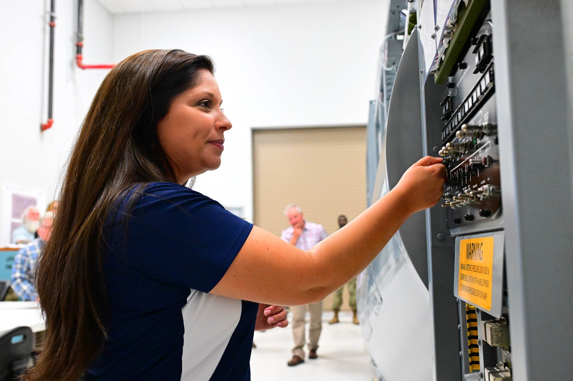 Heather Contant, Delaware Municipal Electric Corporation director of government and community relations, operates a forward and aft loading complex trainer at Dover Air Force Base, Delaware, Oct. 21, 2024. Team Dover provided the DEMEC staff a hands-on tour to familiarize them with the base mission and capabilities. (U.S. Air Force photo by Mauricio Campino)