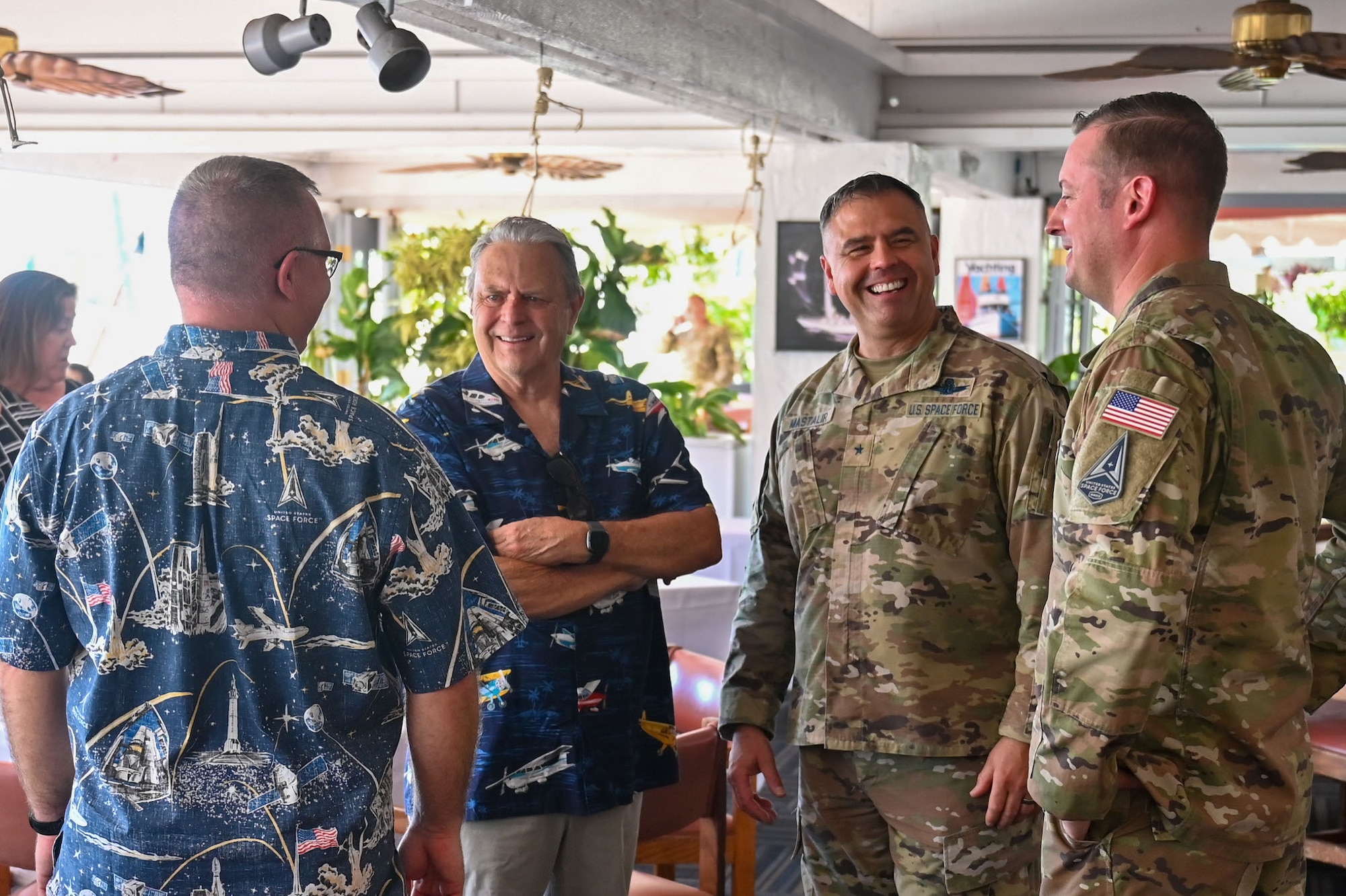 Two military men talk to two community leaders at a restaurant