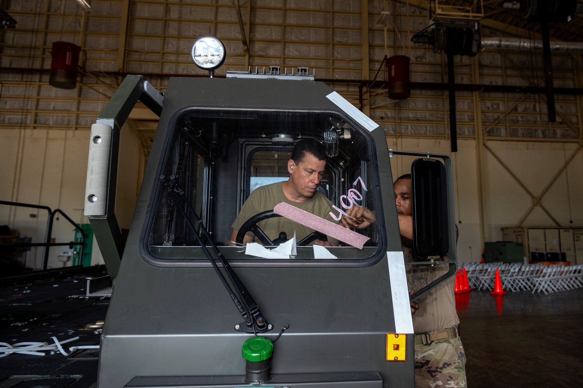 U.S. Air Force Staff Sgt. Maurice Kelly, a vehicle maintenance instructor assigned to the 346th Training Squadron, shows Staff Sgt. Carlos J. Claudio, a vehicle maintenance technician assigned to the 156th Contingency Response Support Squadron, how to operate a Halvorsen 25K Cargo Loader at Muñiz Air National Guard Base, Carolina, Puerto Rico, June 5, 2024.
